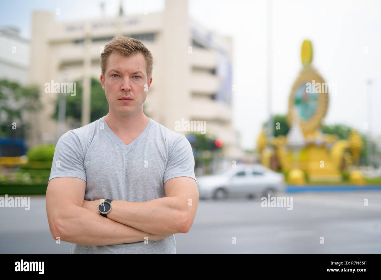 Junge attraktive touristische Mann gegen Ratchadamnoen Straße in Bangkok. Stockfoto