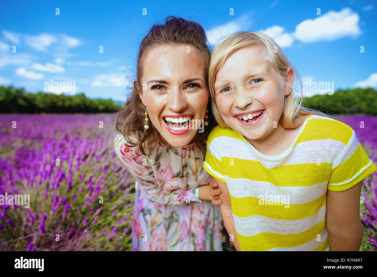 Portrait von lächelnden jungen Mutter und Tochter gegen Lavendelfeld in der Provence, Frankreich. Happy Family Portrait in blühender Lavendel Wiese. Tochter Stockfoto