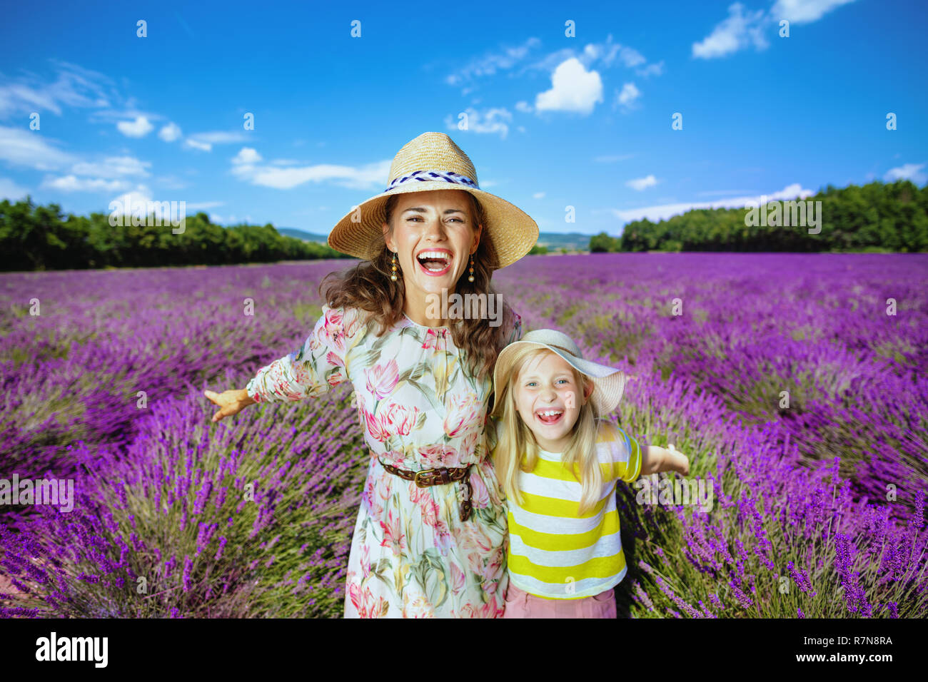 Glückliche junge Mutter und Tochter gegen Lavendelfeld in der Provence, Frankreich. Familie Freude sind froh, dass Sie kamen in die Provence. Lebendige Lavendel fie Stockfoto