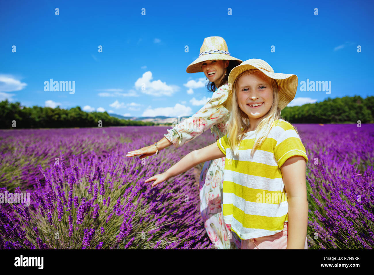 Portrait von Happy stilvolle Mutter und Kind im lavendelfeld in der Provence, Frankreich berühren Lavendel. Mutter und Tochter lernen Sie das ländliche Leben im Süden Stockfoto