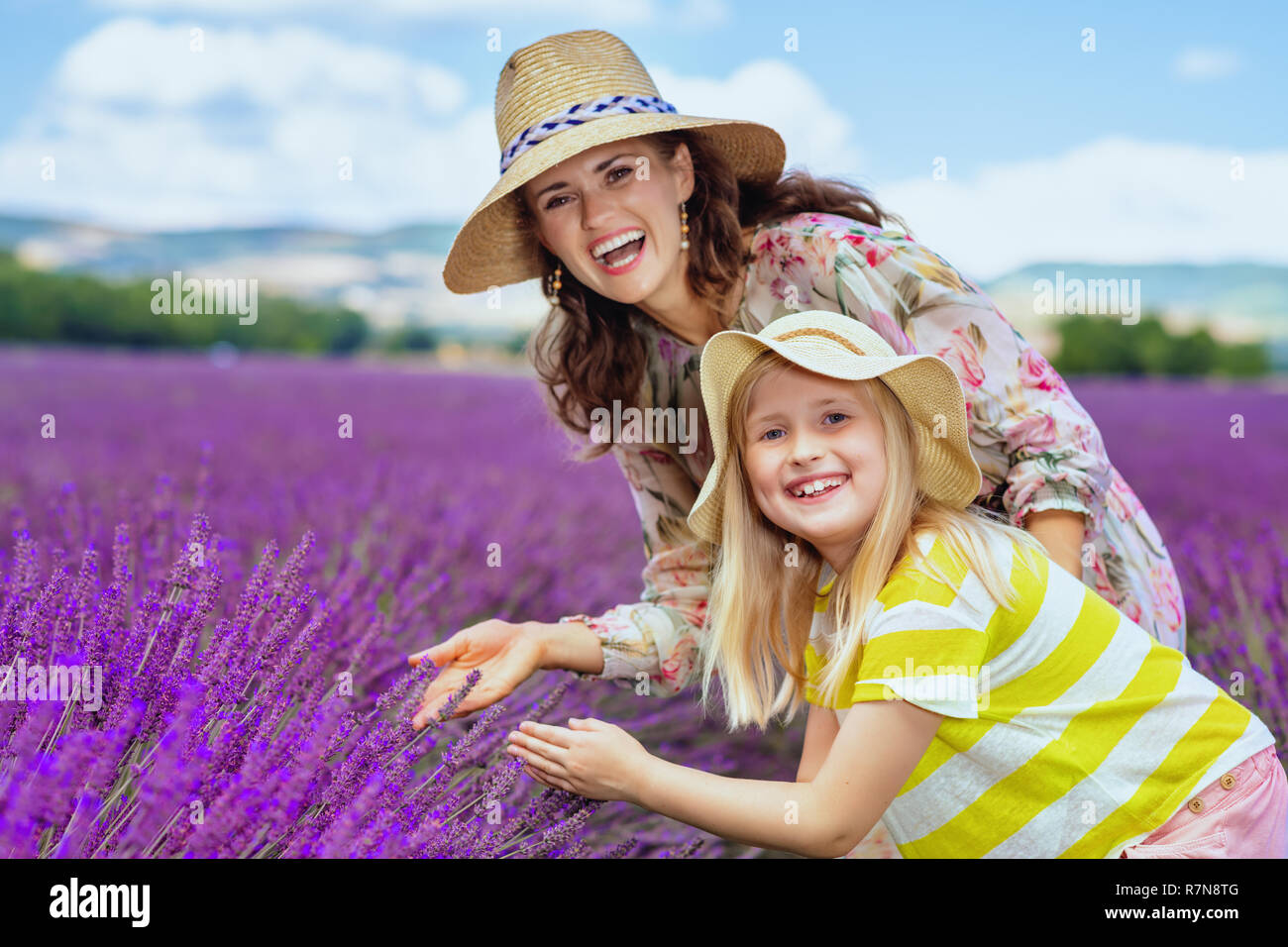 Portrait von trendigen Mutter und Kind Erkundung Lavendel gegen Lavendelfeld in der Provence, Frankreich. Perfekte Familie Agrotourismus mit malerischen Ebenen Stockfoto