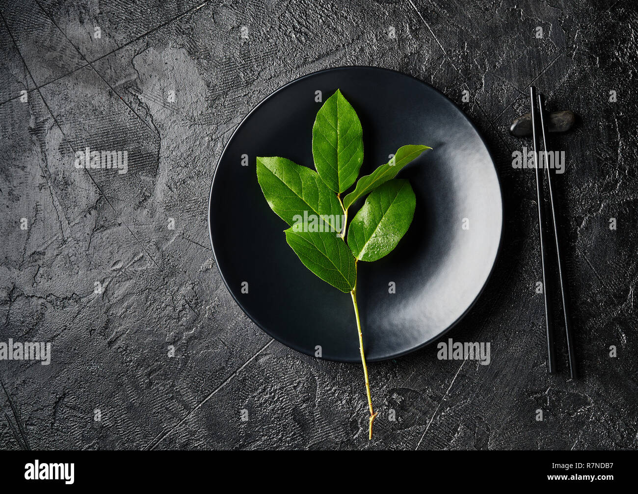 Dunkle leere Platte von asiatische Lebensmittel mit schwarzen Stäbchen auf schwarzem Schiefer. Im asiatischen Stil. Stockfoto