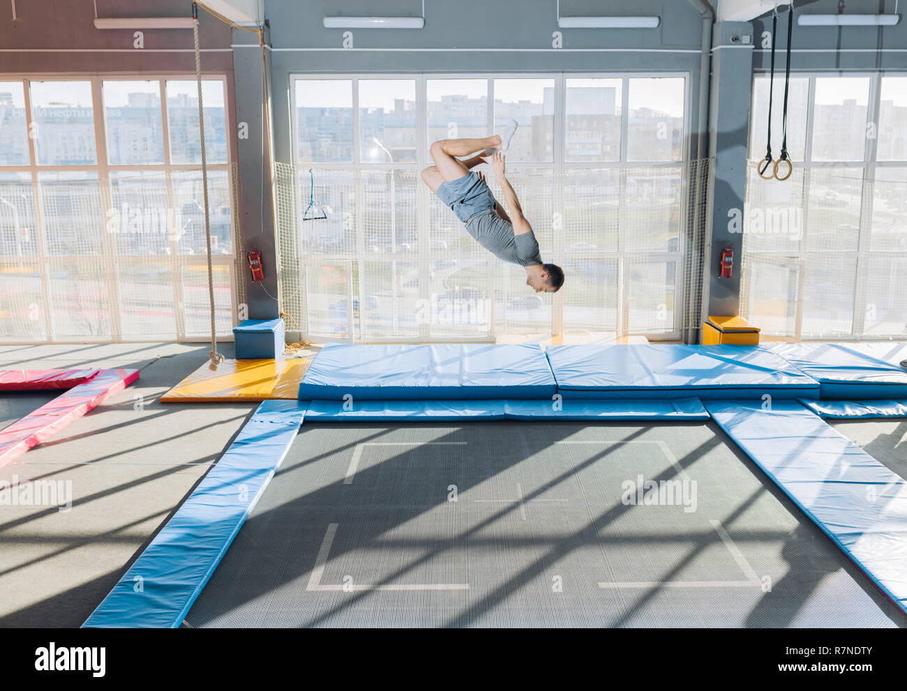 Junge passen flexible Kerl, komplexe Salto auf dem Trampolin Stockfoto