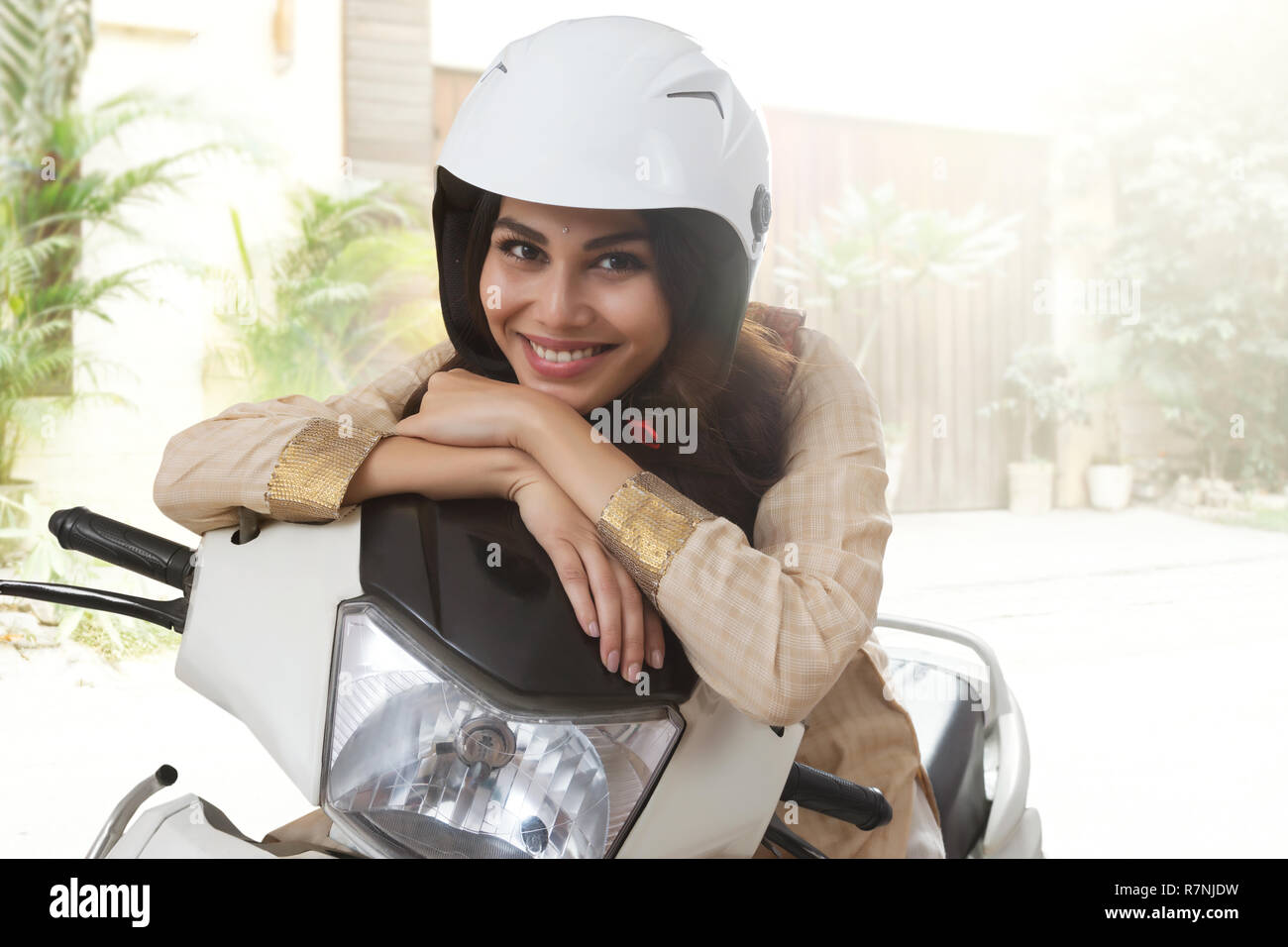 Lächelnden jungen Frau in traditioneller Kleidung sitzt auf einem Roller  Helm Stockfotografie - Alamy