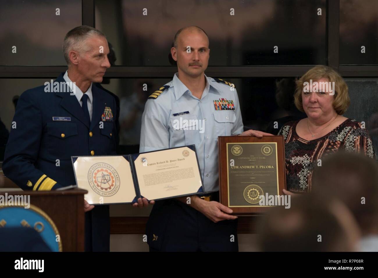 Coast Guard Cmdr. Andrew Pecora, der als Oberfläche Kräfte Logistikzentrum Patrouillenboot Product Line Manager dient, nimmt die 2016 Kapitän Richard D. Poore Auszeichnung bei einem Festakt in der Küstenwache Yard in Baltimore, Md., 21. März 2017. Die Mitgliedstaaten, die zum Teil, dass Pecora erlitten hat Flotte Bereitschaft von 117 Patrouillenboote, überwachte die erfolgreiche Ausführung von über 360 Depot Instandhaltung Projekte auf über $ 160 Mio. bewertet, und ein kombinierten Flotte Verfügbarkeit, dass die operationellen Ziele übertroffen erreicht. Stockfoto