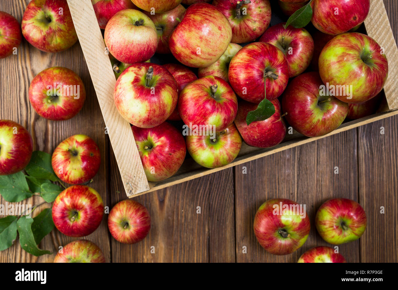 Rote frische Äpfel auf einem hölzernen Tisch in einer Schublade Stockfoto