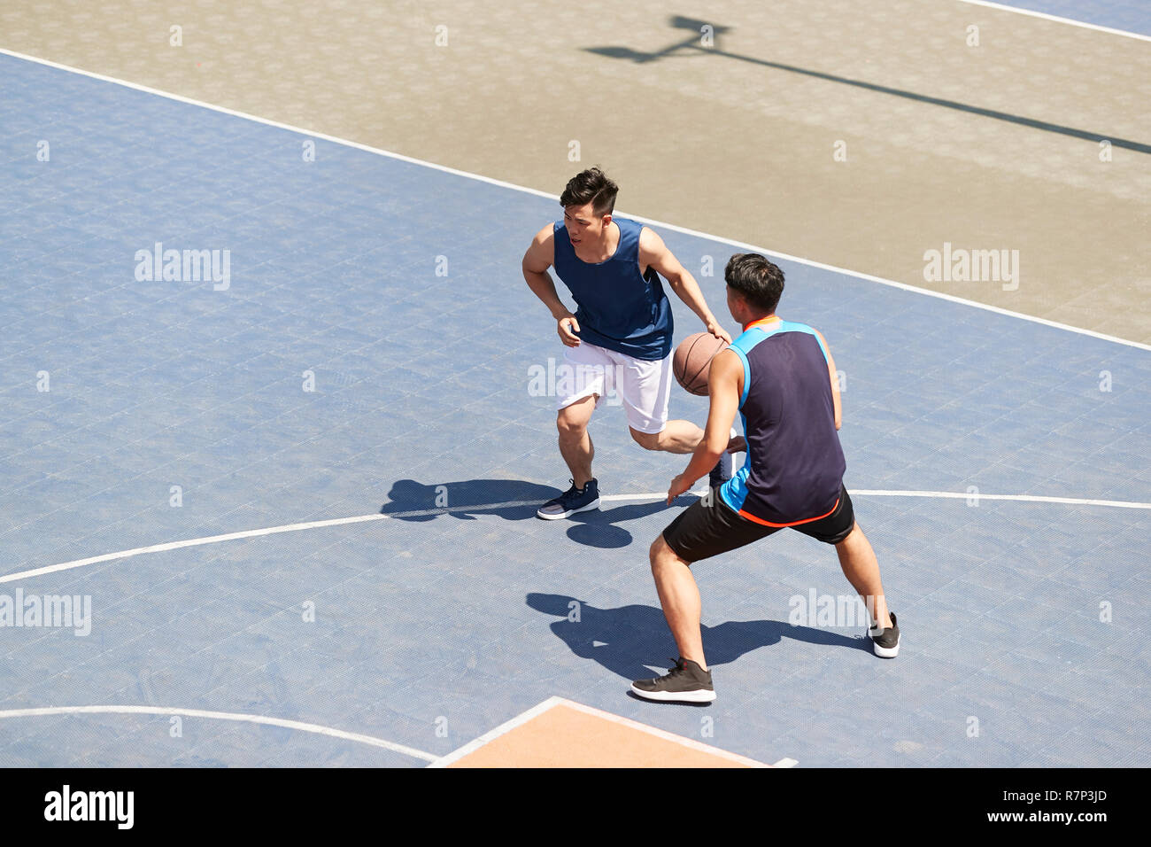 Jungen asiatischen männliche Basketball Spieler ein Spiel spielen Im freien Gericht. Stockfoto