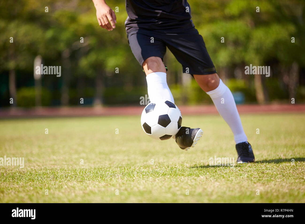 Nahaufnahme der Füße der asiatischen Fußball-Spieler den Umgang mit der Kugel auf dem Fußballplatz. Stockfoto