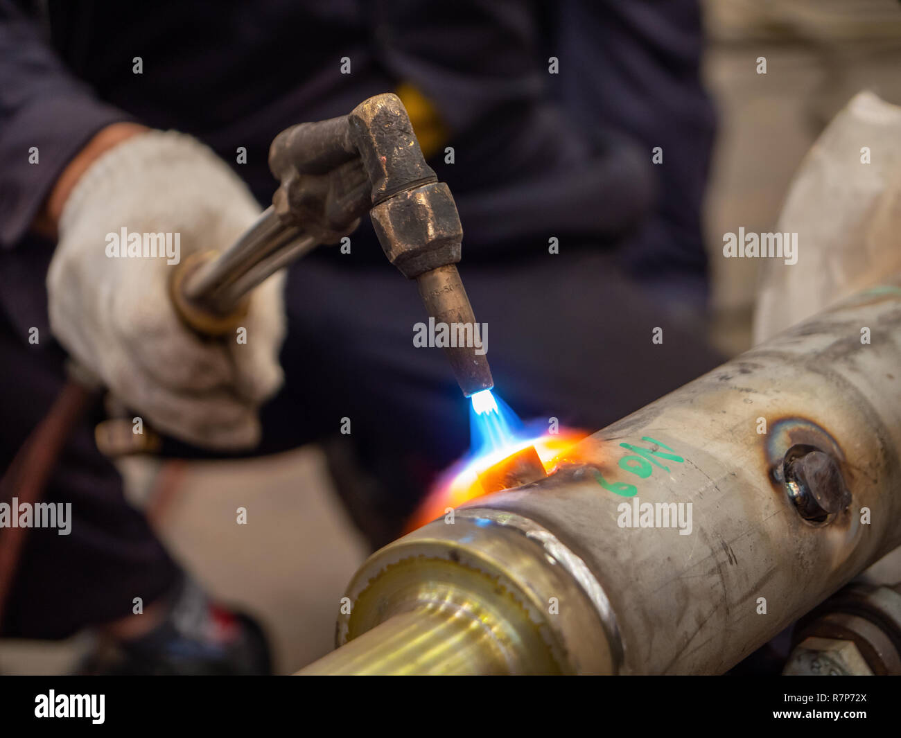 Schweißarbeiten von Edelstahl Industrie teil, die ausgeführt werden. Flache Tiefenschärfe mit der Flamme schweißen im Fokus. Stockfoto