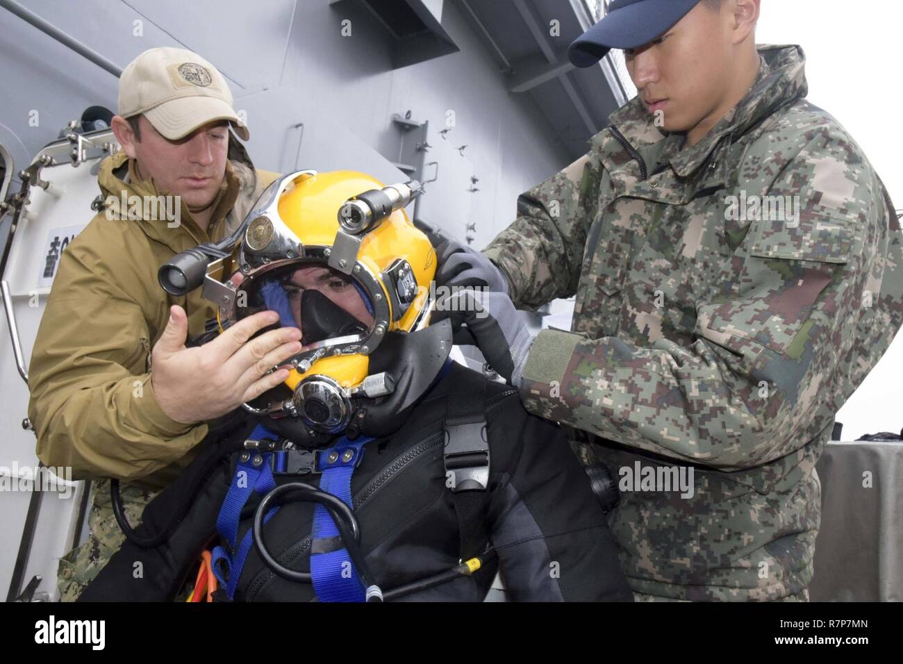 Gewässer, DIE DIE KOREANISCHE HALBINSEL (29. März 2017) Republik Korea (ROK) Marine Hasa (Petty Officer 1st Class) Bae Jun Byum und U.S. Navy Diver 2. Klasse Kyle Fox unterstützen Marine Diver Nick Reese auf Tauchausrüstung, während in der ersten bilateralen Diver Training übung auf ROK Schiff Tong Yeong (ATS 31), während der Bergungsarbeiten Übung (SALVEX) Korea 2017 Teilnehmenden. SALVEX Korea 2017 ist Teil der Übung Fohlen Adler, eine Reihe von gemeinsamen und kombinierten Feld Übungen, was ein Beweis für die Verpflichtung der USA, der Republik Korea und den USA Allianz, und verbessert die Bekämpfung der Bereitschaft, flexib Stockfoto
