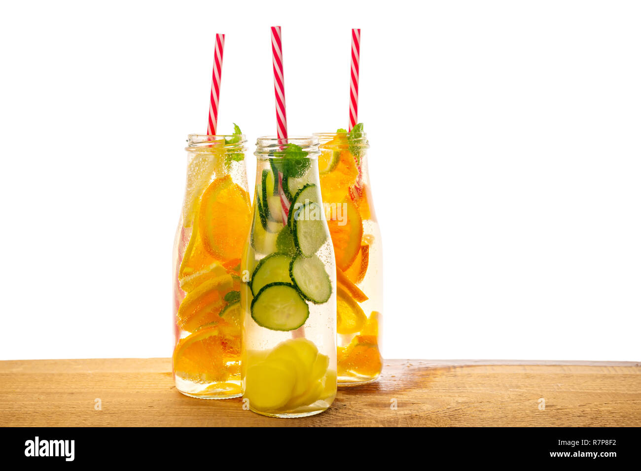 Flaschen Limonade mit Zitrone, Orange, Limette, Zweig, Minze, Gurke, Ingwer und Strohhalme auf hölzernen Hintergrund, Konzept der gesunden Lebensstil Stockfoto