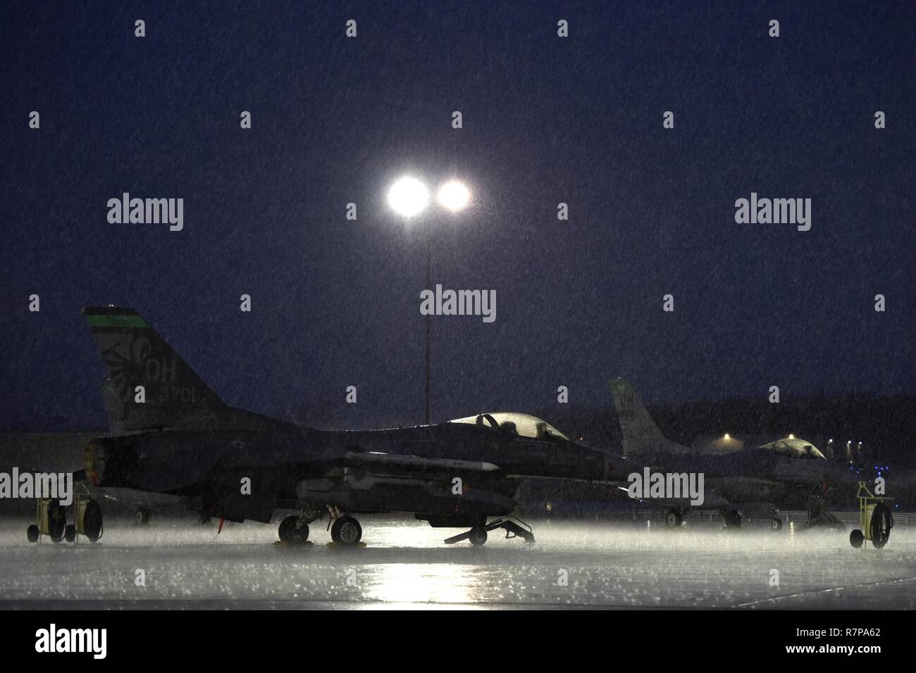 Eine F-16 Fighting Falcon sitzt auf dem Flug Linie März 30, 2017 180 Fighter Wing, Ohio Air National Guard in Swanton, Ohio während ein Frühling Sturm. Die F-16 ist ein kompakter, multi-role Fighter Aircraft, die sehr wendig ist und hat sich bewährt in der Luft-zu-Luft bekämpfen und Luft-zu-Oberfläche angreifen. Stockfoto