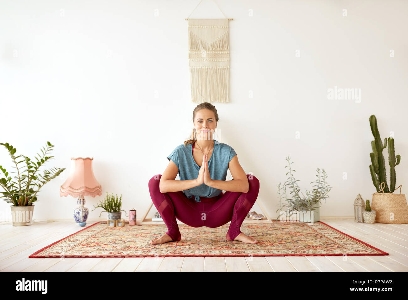 Junge Frau tun Garland bei Yoga Studio darstellen Stockfoto