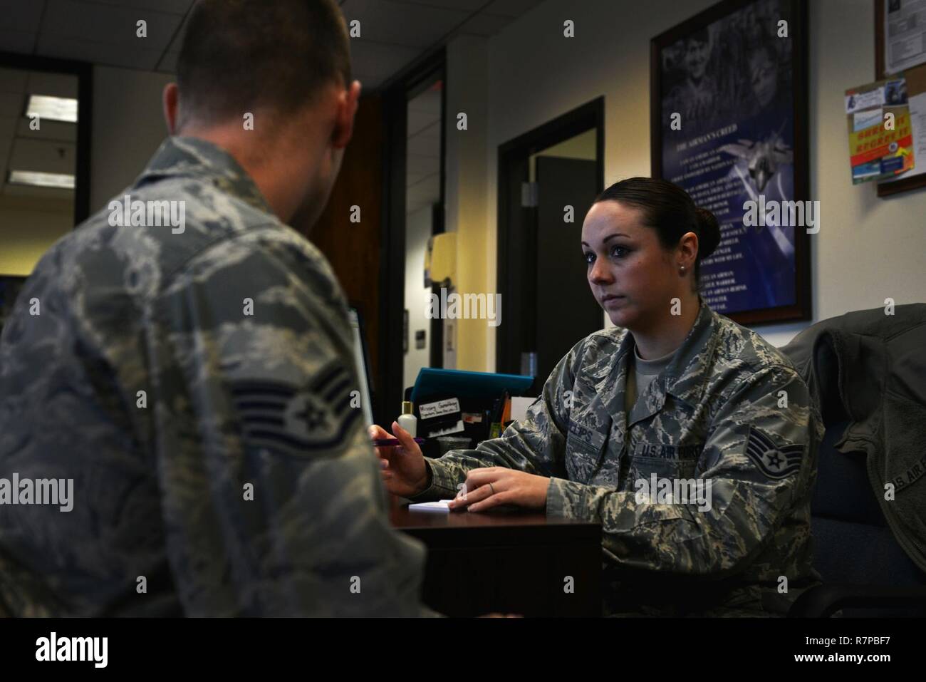 Us Air Force Staff Sgt. Rachael Phillips, 20 Force Support Squadron reenlistments noncommissioned Officer zuständig, hilft einem Kunden bei Shaw Air Force Base, S.C., 20. März 2017. Die reenlistments Büro des militärischen Personals Abschnitt hilft Service Mitglieder zu erweitern, reenlist und erhalten keine Boni auf reenlistment berechtigt sein kann. Stockfoto