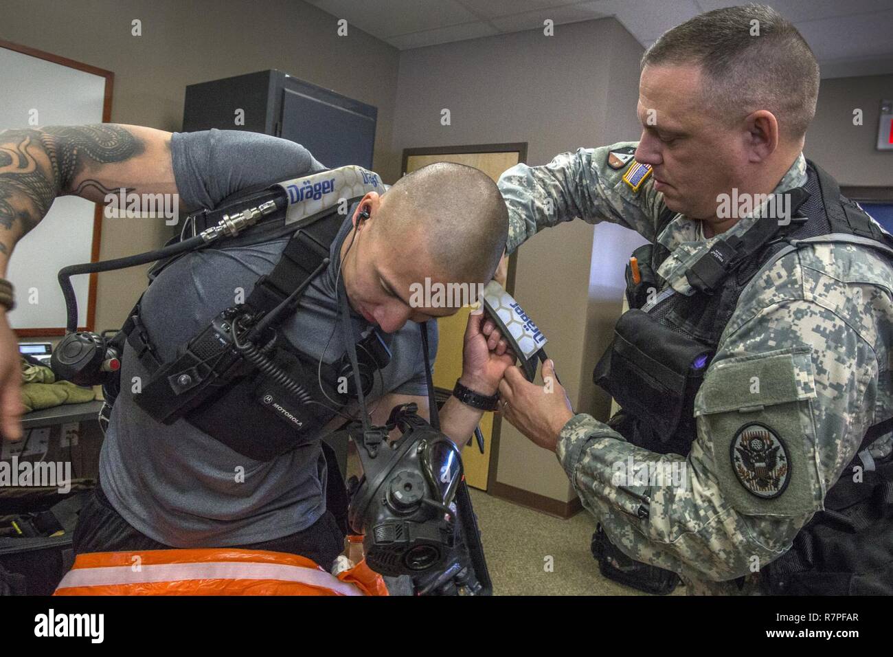 Emergency Medical Technician Sgt. 1. Klasse Anthony Norrish, rechts, unterstützt Strike Team Mitglied Staff Sgt. Nicky Lam, beide mit 21 Waffen der New Jersey National Guard von Mass Destruction-Civil Support Team, mit seinem Umluftunabhängiges Atemschutzgerät und Re-Entlüftung während einer Übung mit dem Picatinny Arsenal Feuerwehr am New Jersey Homeland Defense Homeland Security Center am Picatinny Arsenal, N. J., März 23, 2017. Das 21 WMD-CST ist eine gemeinsame Einheit aus New Jersey National Guard Soldaten und Piloten, deren Aufgabe es ist, der zivilen Behörden durch die Identifizierung von ch unterstützen Stockfoto