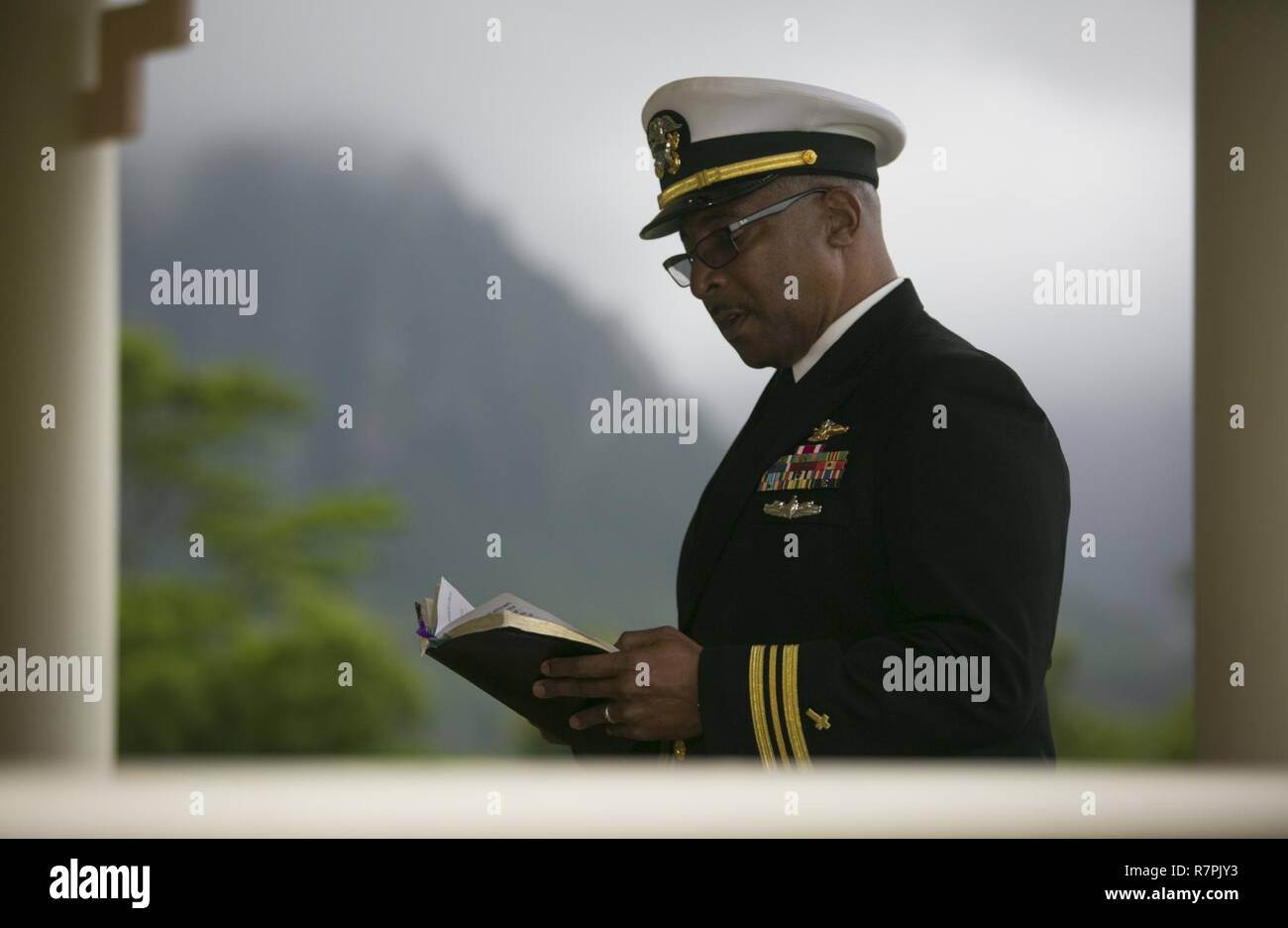 Lt.Cmdr. Philip Ridley, der Marine Corps Base Hawaii Kaplan, sagt ein Gebet an der Trauerfeier für pensionierte Marine Col. Vincil W. Hazelbaker, an der Hawaiianischen Memorial Park Friedhof am 24. März 2017. Nach der Zeremonie, Hubschrauber aus marinen Flugzeuge Gruppe 24 führte eine fehlende Mann Formation, die eine Antenne salute während ein Flypast von Flugzeugen an einer Gedenkfeier durchgeführt, in der Regel in Erinnerung an einen gefallenen Piloten. Hazelbaker war ein Marine Piloten, im Militär für 34 Jahre gedient. Während seines Dienstes, flog er mehr als 680 Einsätze und erwarb die Marine Kreuz für seine Entscheidung fiel Stockfoto