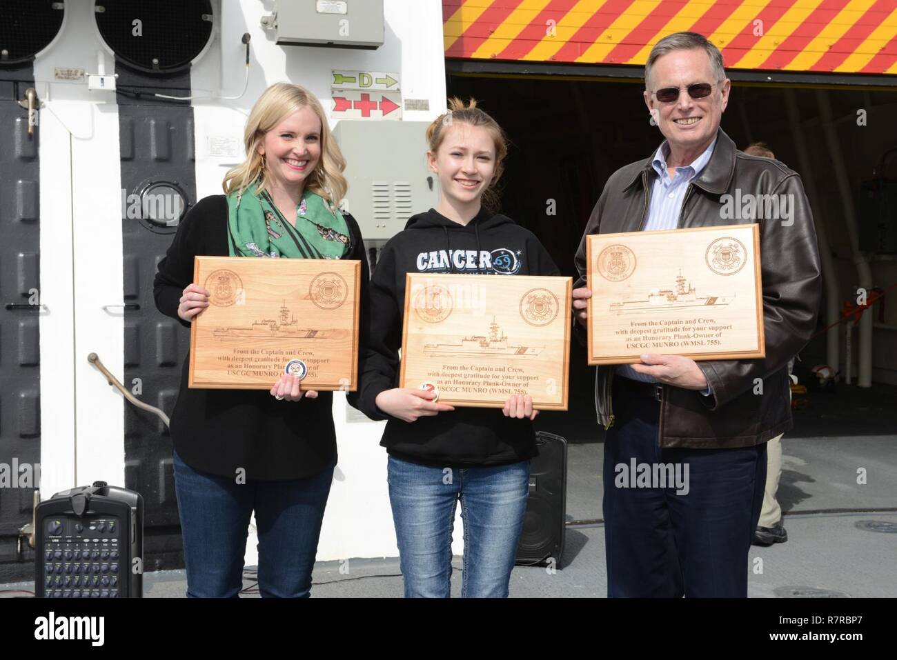 Julie, Eliza und Douglas Sheehan, Nachfahren der Küstenwache held Einweisende 1. Klasse Douglas Munro, halten ehrenamtliche Plank owner Plaques und Einheit Münzen begabt zu Ihnen aus der Kapitän und die Besatzung der Coast Guard Cutter Munro in Seattle, 31. März 2017. Plank Besitzer ist ein nautischer Begriff, bezeichnet jemanden, der aktiv in der Bau eines Schiffes tätig war und in der Einheit gedient, nachdem das Schiff in Betrieb genommen wurde und in Betrieb gesetzt. Us-Küstenwache Stockfoto