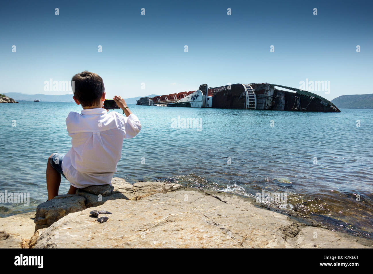 Junge fotografieren sinkendes Schiff Stockfoto