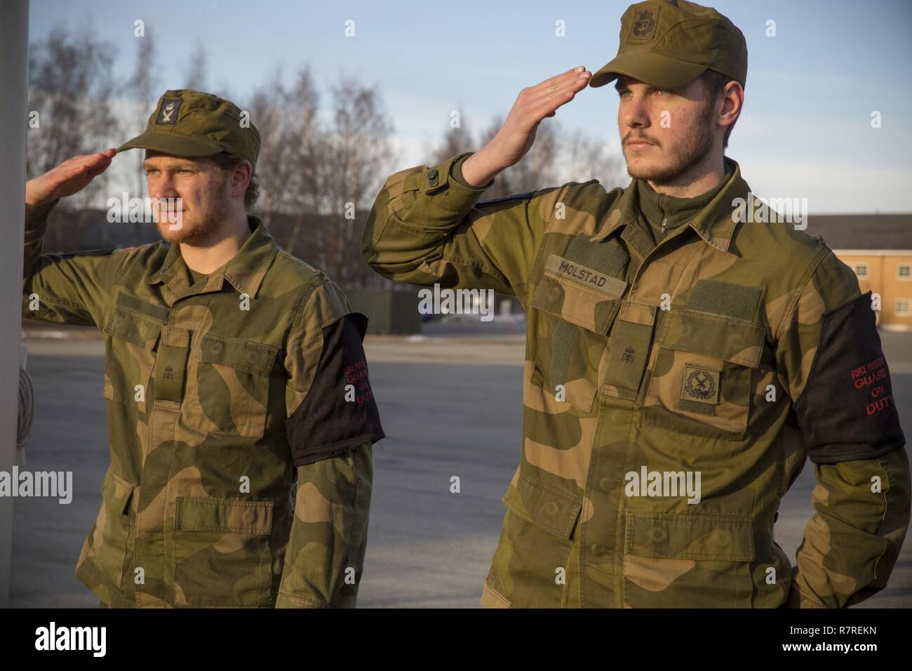 Soldaten mit Home Guard 12 Grüßet die norwegische Flagge an vaernes Garnison, 30. März 2017. Marine Drehkraft Europa 17,1 (MRF-E) ist nach Norwegen bereitgestellt und führt die Farben neben Norwegischen Truppen jeden Morgen. MRF-E hält an Traditionen und baut auf einem Fundament von gemeinsamen Werten, Erfahrungen und Visionen mit Verbündeten und Partner Nationen. Stockfoto