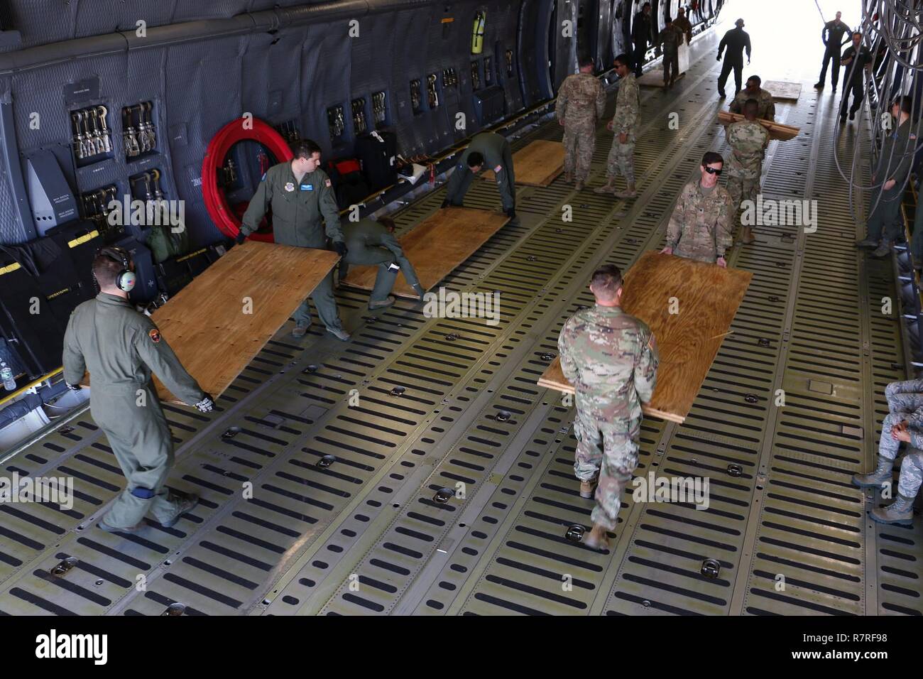 Soldaten und Piloten sperrholz Entladen für Luft Ausbildung März 28, 2017 Hunter Army Airfield, Ga. Das Sperrholz ist eine Barriere zwischen Flugzeug der C5 Super Galaxy' und der Abrams Panzer und Bradley, die Bekämpfung der Fahrzeuge des 2nd Battalion, 7th Infantry Regiment, 1st Armored Brigade Combat Team, 3rd Infantry Division. Soldaten von 2-7. Inf. Bilden die unmittelbare bereit, Firma, die behauptet, die Bereitschaft der Global Response Force innerhalb von 18 Stunden nach der Benachrichtigung zu unterstützen. Stockfoto