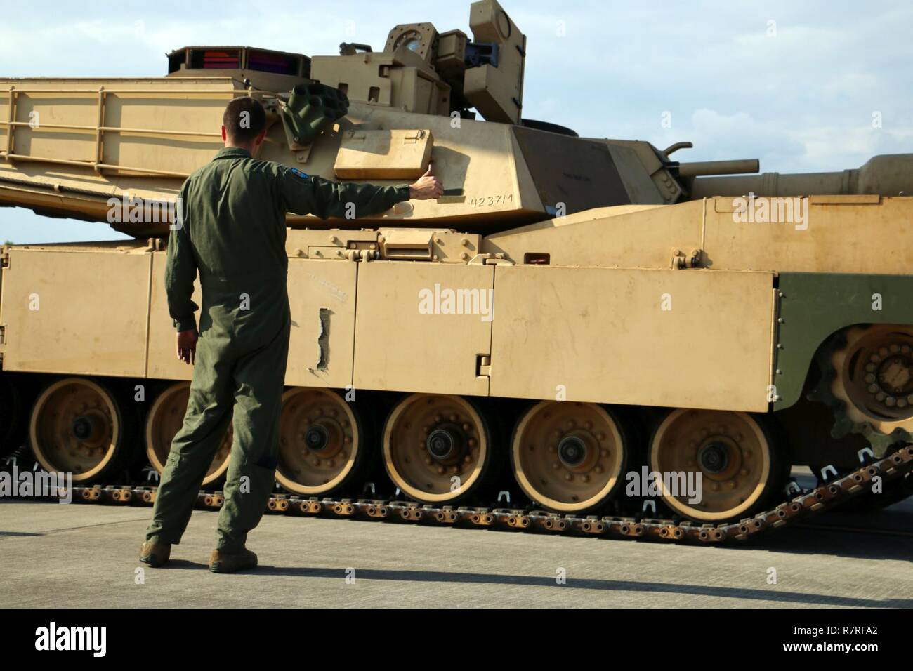 Einen Flieger mit 9 Airlift Squadron, 436Th Airlift Wing aus Dover Air Force Base, Del leitet eine M1A1 Abrams Tank aus einer C5 Super Galaxy' Flugzeuge während Luft Ausbildung März 28, 2017 Hunter Army Airfield, Ga Flieger unterstützt die sofortige bereit, Unternehmen, bestehend aus Soldaten aus dem 2., 7. Bataillon der Infanterie Regiment, 1st Armored Brigade Combat Team, 3rd Infantry Division. Der IRC unterhält die Bereitschaft der Global Response Force innerhalb von 18 Stunden nach der Benachrichtigung zu unterstützen. Stockfoto