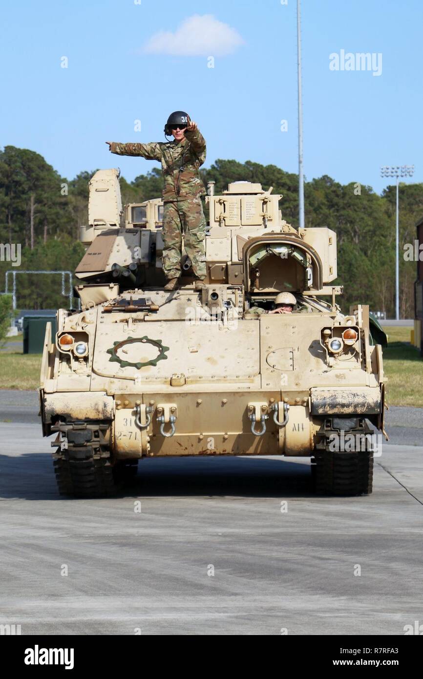 Ein Soldat mit 2Nd Battalion, 7th Infantry Regiment, 1st Armored Brigade Combat Team, 3rd Infantry Division gibt Richtungen zu einem Luft crewman vor Laden eines M2A3 Bradley fighting Fahrzeug auf einer C5 Super Galaxy' Flugzeuge während Luft Ausbildung März 28, 2017 Hunter Army Airfield, Ga Soldaten von 2-7. Inf. Bilden die unmittelbare bereit, Firma, die behauptet, die Bereitschaft der Global Response Force innerhalb von 18 Stunden nach der Benachrichtigung zu unterstützen. Stockfoto