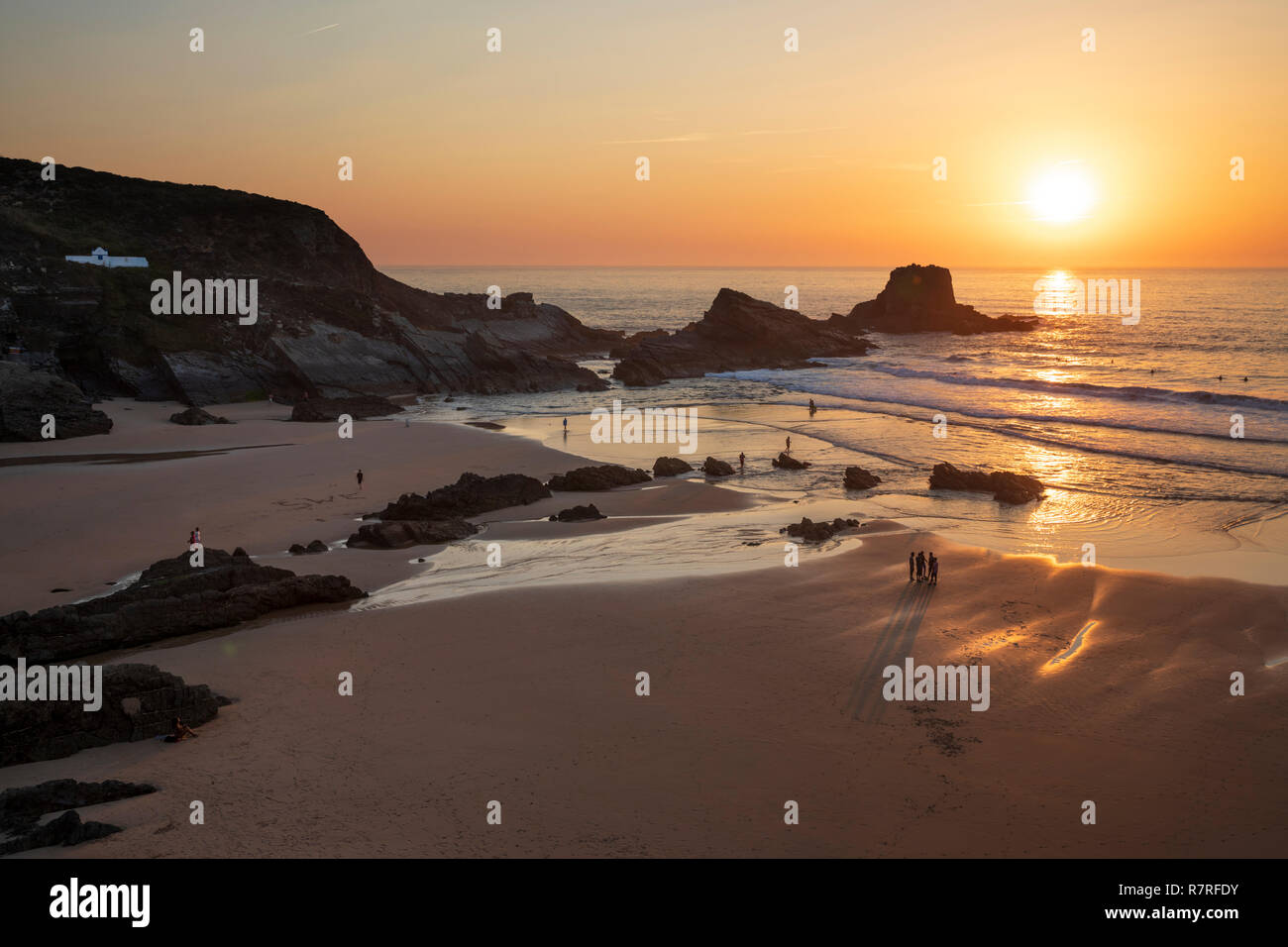 Atlantik Wellen auf den Strand und die Felsen bei Sonnenuntergang brechen, Zambujeira do Mar, Alentejo, Portugal, Europa Stockfoto