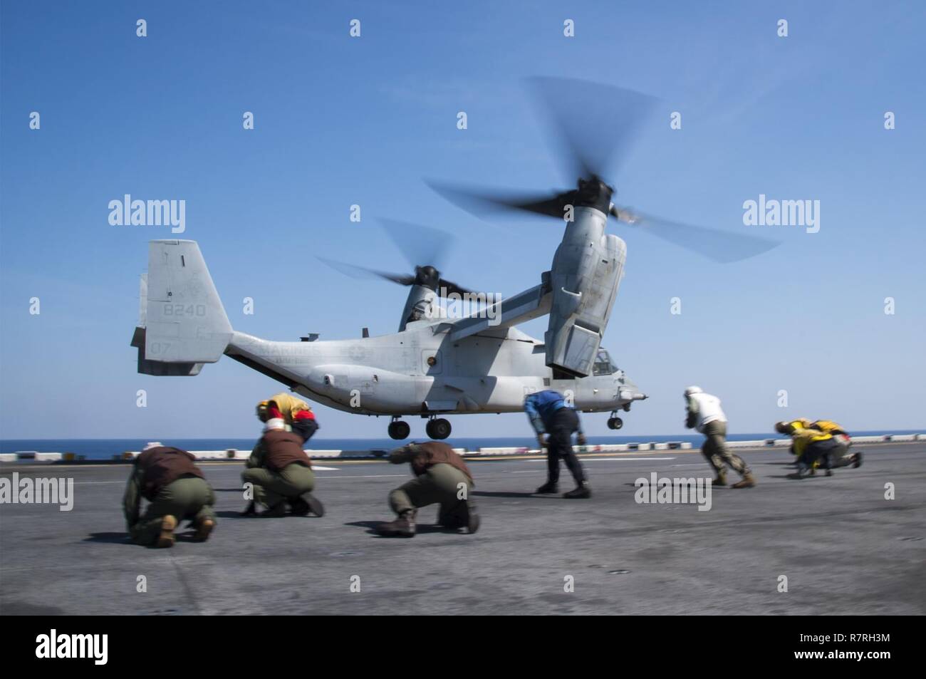 EAST CHINA SEA (4. April 2017) Matrosen und Marines auf den Rotor waschen als B MV-22 Osprey, zugeordnet zu den "Flying Tigers" der Marine Medium Tiltrotor Squadron (VMM) 262, zieht aus der Flight Deck des Amphibious Assault ship USS BONHOMME RICHARD (LHD6) während der squadron Ausschiffung strebe. Bonhomme Richard, dem Flaggschiff der Bonhomme Richard Expeditionary Strike Group, mit 31 Marine Expeditionary Unit begonnen, ist auf einer Routinepatrouille in der Indo-Asia - Pazifik Region warfighting Bereitschaft und Haltung als ready-Response Force für jede Art von contingen verbessern Stockfoto