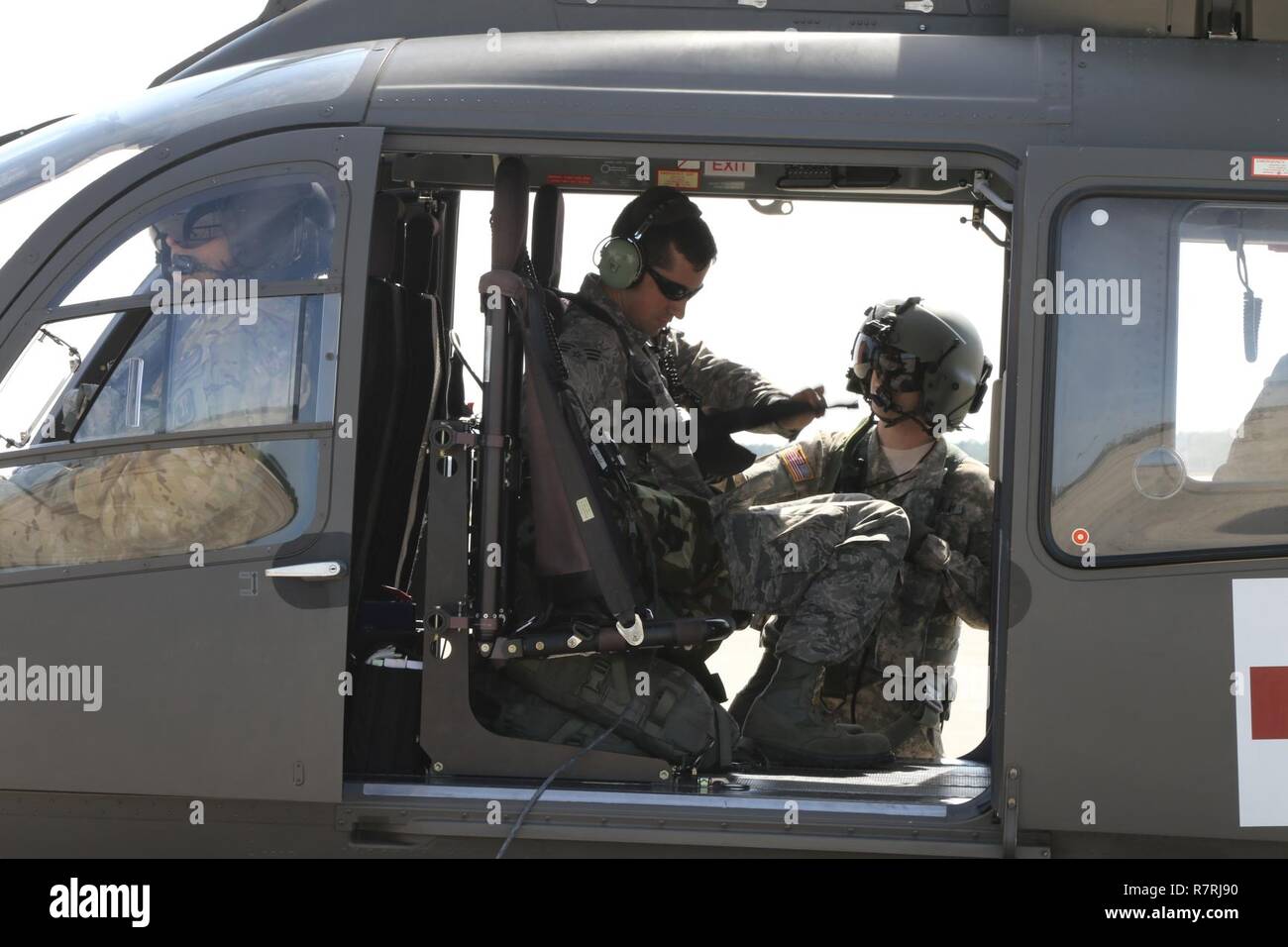 Eine Armee Guard Crew Chief sichert ein Guard Flieger in den Sitz der UH-72A Lakota Hubschrauber an der Bekämpfung der Readiness Training Center, Gulfport, Mississippi, am 4. April 2017. Die Einarbeitung der Flug war in der Vorbereitung der Übung Marlinspike II, eine Untersuchungskommission Übung für eine einheitliche Reaktion auf Massenvernichtungswaffen Bedrohungen entwickelt. (Mississippi National Guard Stockfoto