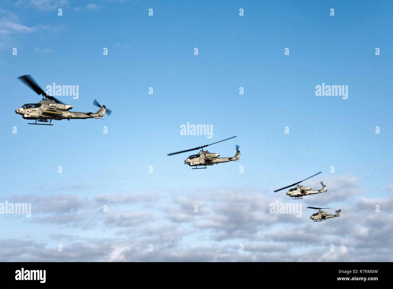 BUCKNER BAY (5. April 2017) vier AH-1W Super Cobra Hubschraubern, zugeordnet zu den Marine Medium Tiltrotor Squadron (VMM) 262 (verstärkt), fliegen Sie über den amphibious Transport dock USS Green Bay LPD (20). Green Bay, Teil der Bonhomme Richard Expeditionary Strike Group, mit 31 Marine Expeditionary Unit begonnen, ist auf Patrouille, die in der Indo-Asia - Pazifik Region warfighting Bereitschaft und Haltung als ready-Response Force für jede Art der Kontingenz zu verbessern. Stockfoto