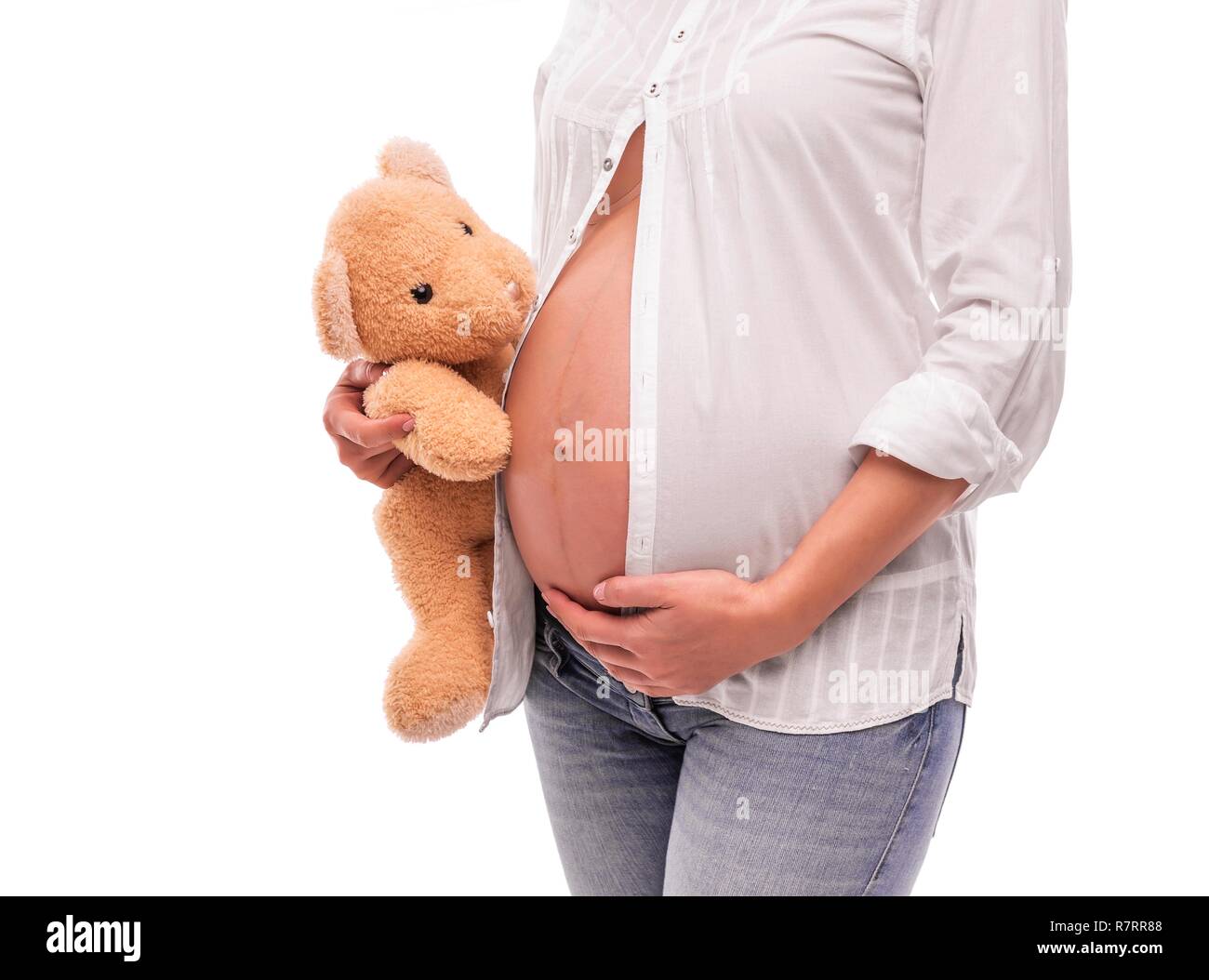 Schwangere Frau hält ein Bär in der Nähe des Bauches. Stockfoto