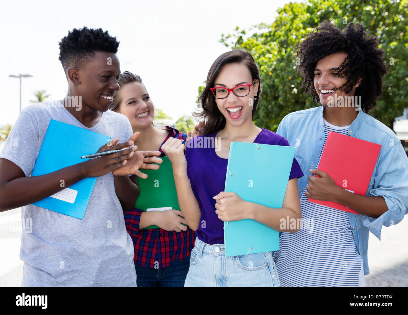 Jubelnde nerdy Student mit einer Gruppe von Studenten internternational Outdoor in der Stadt Stockfoto