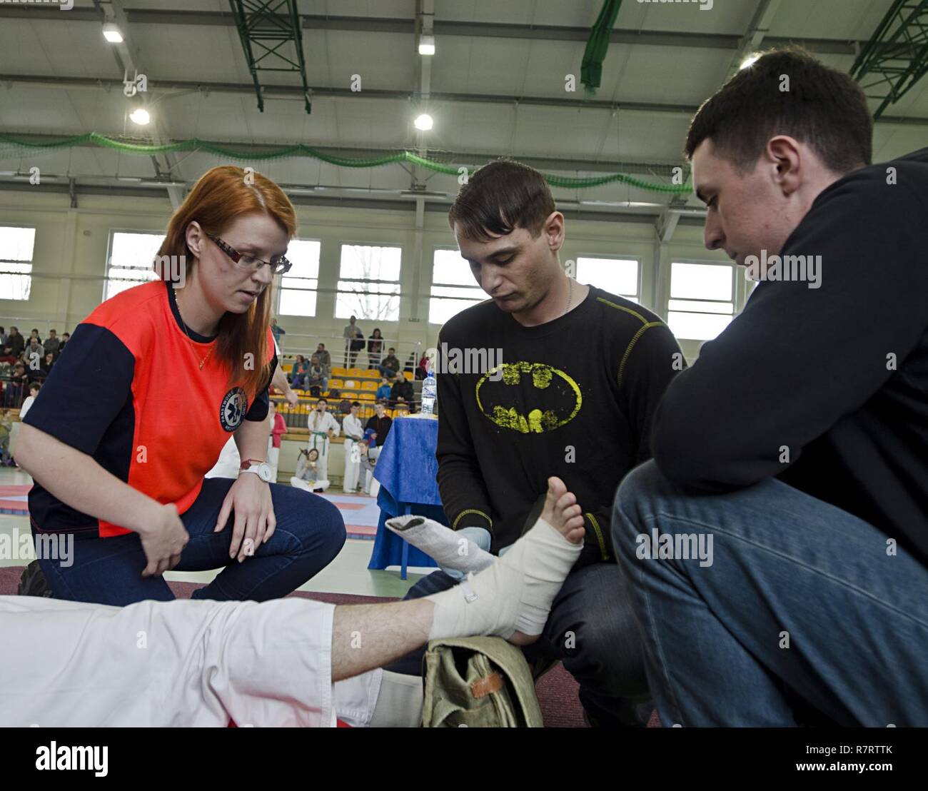 Cpl. Cameron Kinnear und Pfc. Christopher Greco mit 3.Bataillon, 29 Field Artillery Regiment, 3. gepanzerte Brigade Combat Team, 4 Infanterie Division, arbeiten mit einem lokalen Emergency Medical Service (EMS) Medic eine Schiene ein Kämpfer Knöchel während der westlichen Polen Open Championship Karate Turnier in Ilowa, Polen April 8, 2017 zu stabilisieren. Priorität Bravo Batterie ist die Interoperabilität mit der Polnischen Armee zu erhalten, jedoch, Tasking US-Soldaten mit einem polnischen Emergency Medical Service (EMS) Team für eine lokale Veranstaltung hilft Beziehungen innerhalb der polnischen Gemeinschaften stärken zu arbeiten. Stockfoto