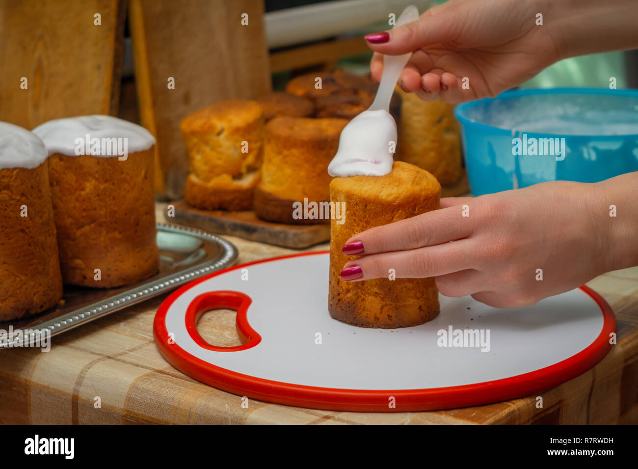 Die Frau ist mit einem süßen Glasur auf Ostern Kuchen. Stockfoto