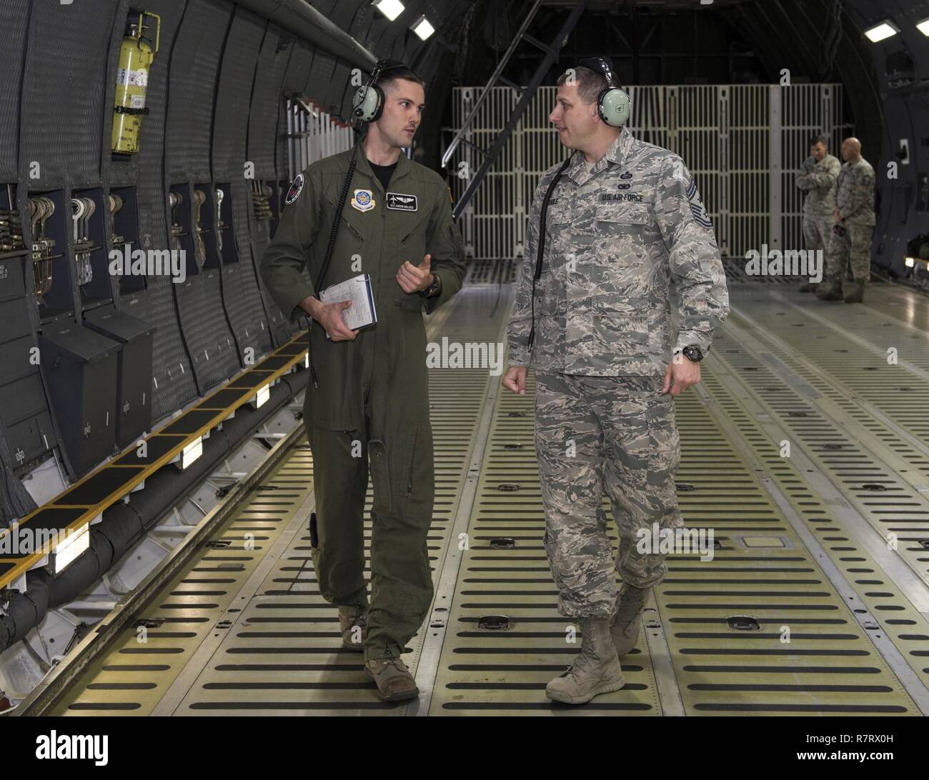 Chief Master Sgt. Steve Nichols, 60 Air Mobility Wing Befehl Chef und Flieger 1. Klasse Aaron Walker, 22. Airlift Squadron, zusammengetan, um Loadmaster Aufgaben an Travis Air Force Base, Kalifornien, 7. April 2017 als Teil der Werke mit Flieger-Programm. Walker ging Nichols durch den Prozess der eine Belastung eine hohe Mobilität Mehrzweck Rädern Fahrzeug (HMMWV) in eine C5-M Super Galaxy-Flugzeug. Die Werke mit Flieger-Programm soll Flügel Führung ermöglichen die Möglichkeit, Schatten junior eingetragenen Flieger und erhalten aus erster Hand Erfahrungen wie der Flieger Pflichten und Verantwortlichkeiten schwie- Stockfoto
