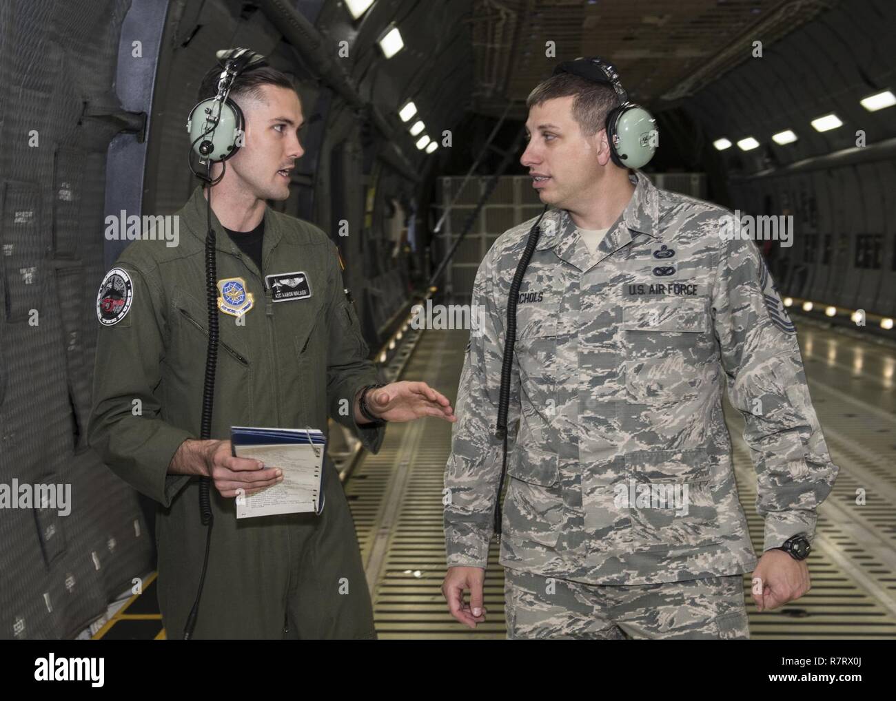 Chief Master Sgt. Steve Nichols, 60 Air Mobility Wing Befehl Chef und Flieger 1. Klasse Aaron Walker, 22. Airlift Squadron, zusammengetan, um Loadmaster Aufgaben an Travis Air Force Base, Kalifornien, 7. April 2017 als Teil der Werke mit Flieger-Programm. Walker ging Nichols durch den Prozess der eine Belastung eine hohe Mobilität Mehrzweck Rädern Fahrzeug (HMMWV) in eine C5-M Super Galaxy-Flugzeug. Die Werke mit Flieger-Programm soll Flügel Führung ermöglichen die Möglichkeit, Schatten junior eingetragenen Flieger und erhalten aus erster Hand Erfahrungen wie der Flieger Pflichten und Verantwortlichkeiten schwie- Stockfoto