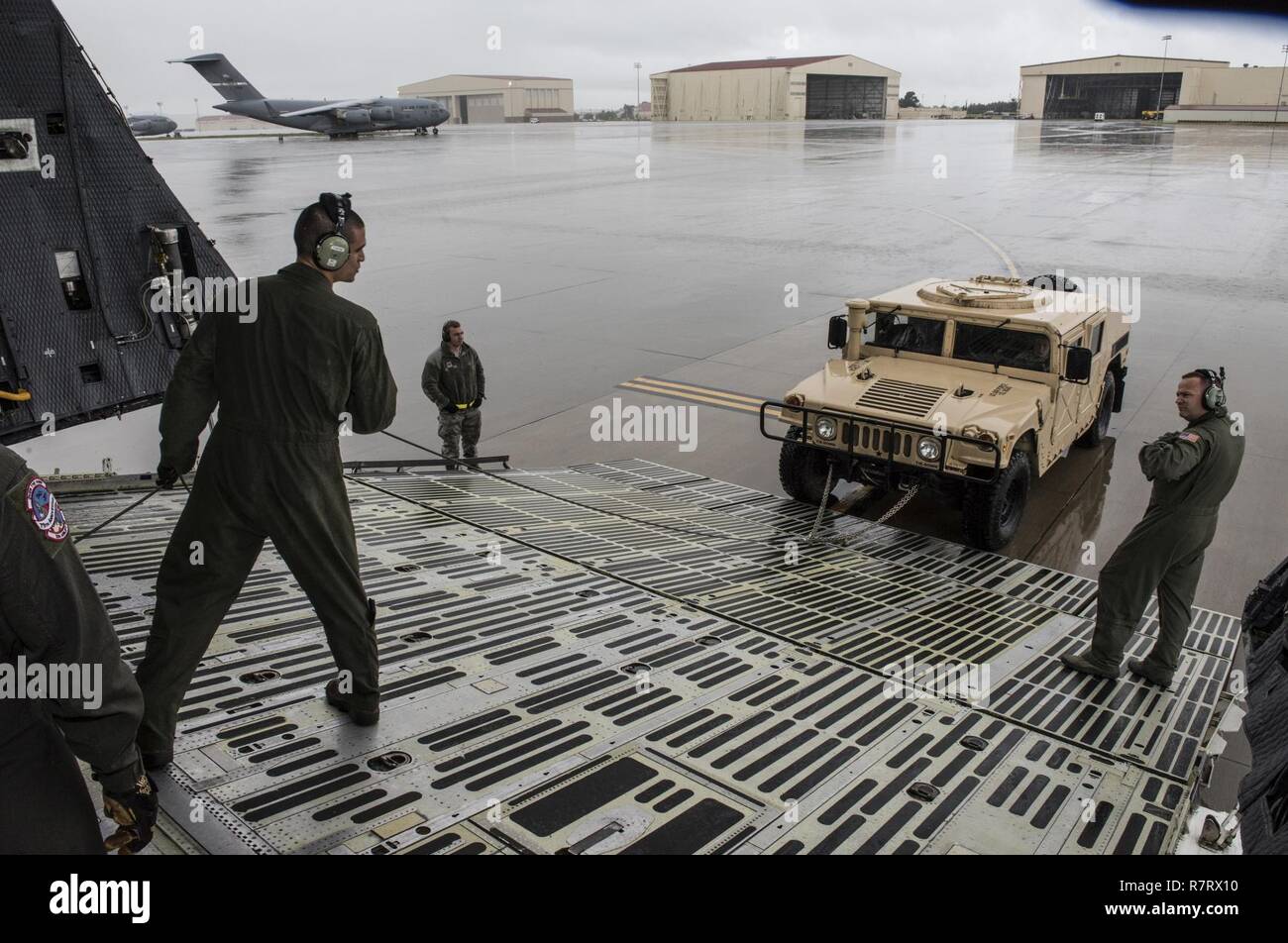 Us Air Force Aircrew Mitglieder für die 22 Airlift Squadron Arbeit zu laden und sichern eine hohe Mobilität Multipurpose Radfahrzeug (Hmmwv) auf eine C5-M Super Galaxy Flugzeuge während der arbeitet mit Flieger Programm, 7. April 2017. Das Programm sieht die Führung der Interaktion mit Fliegern eine detaillierte Ansicht der Mission bei Travis durchgeführt. Stockfoto