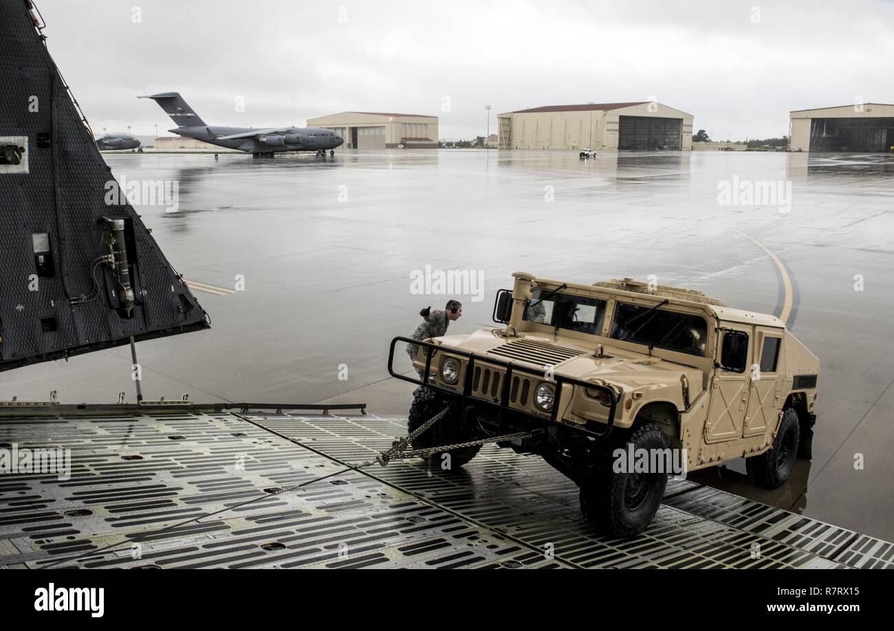 Us Air Force Aircrew Mitglieder für die 22 Airlift Squadron Arbeit zu laden und sichern eine hohe Mobilität Multipurpose Radfahrzeug (Hmmwv) auf eine C5-M Super Galaxy Flugzeuge während der arbeitet mit Flieger Programm, 7. April 2017. Das Programm sieht die Führung der Interaktion mit Fliegern eine detaillierte Ansicht der Mission bei Travis durchgeführt. Stockfoto