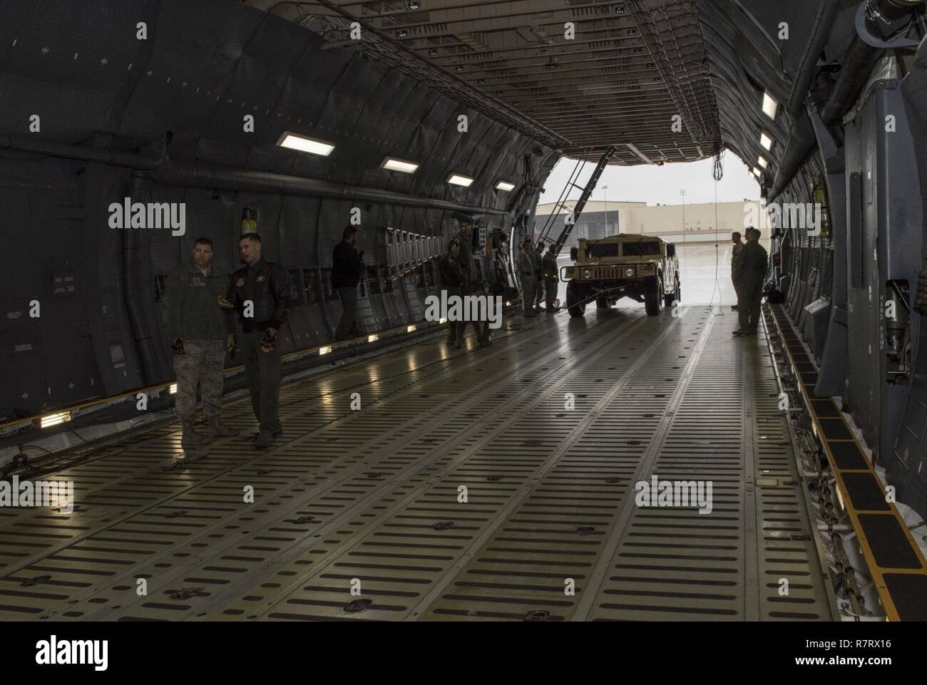 Us Air Force Aircrew Mitglieder für die 22 Airlift Squadron Arbeit zu laden und sichern eine hohe Mobilität Multipurpose Radfahrzeug (Hmmwv) auf eine C5-M Super Galaxy Flugzeuge während der arbeitet mit Flieger Programm, 7. April 2017. Das Programm sieht die Führung der Interaktion mit Fliegern eine detaillierte Ansicht der Mission bei Travis durchgeführt. Stockfoto