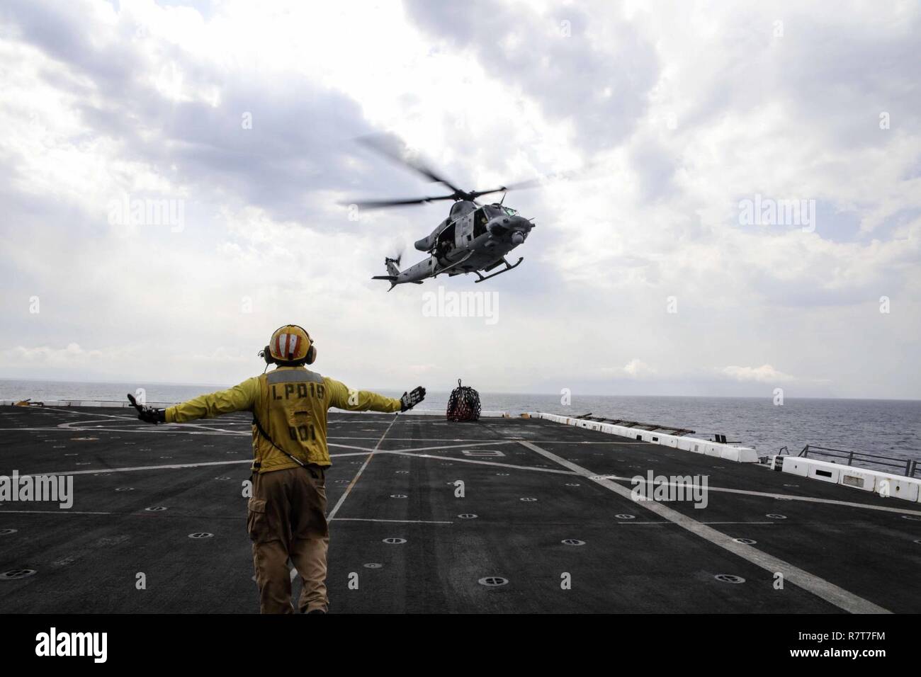 Mittelmeer (5. April 2017) Chef der Luftfahrt Bootsmann Mate (Handling) Eugene Williams, zugeordnet zu den amphibious Transport dock Schiff USS Mesa Verde LPD (19), Signale Ein UH-1Y Huey Hubschrauber der Marine Medium Tiltrotor Squadron (VMM) 365 (verstärkt), nachdem es während einer vertikalen Nachschub liefert. Mesa Verde ist mit dem Bataan Amphibious Ready Gruppe implementiert Maritime Security Operations und Theater Sicherheit Zusammenarbeit in den USA 6 Flotte Bereich der Aktivitäten zu unterstützen. Stockfoto
