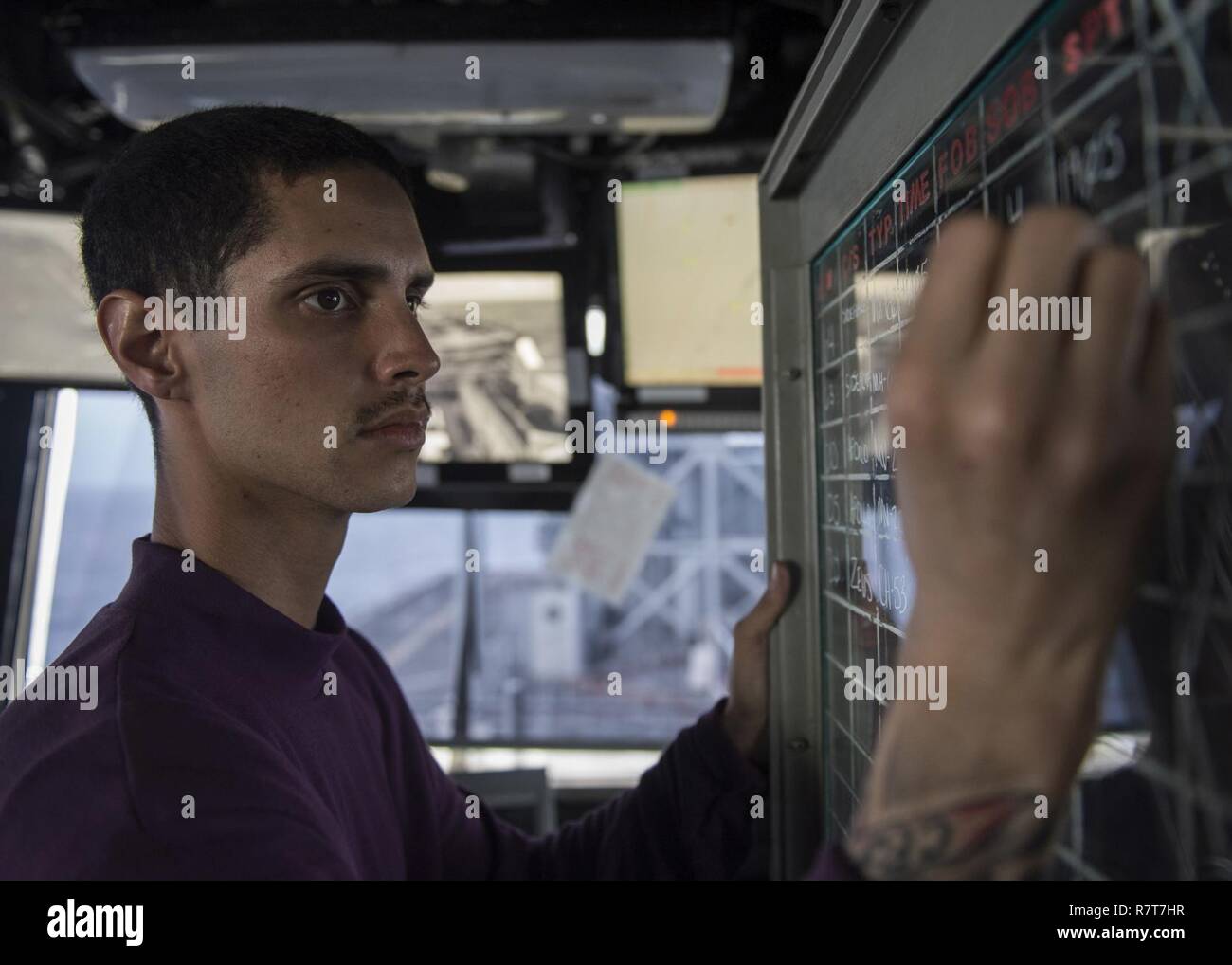 SOUTH CHINA SEA (4. April 2017) der Luftfahrt Bootsmann Mate (Kraftstoff) 3. Klasse Brian Franz, von Barstow, Calif., Updates der Flug Status board im Primary Flight Control an Bord der Amphibisches Schiff USS Makin Island (LHD8). Makin Island, das Flaggschiff der Makin Island amphibischen bereit, mit der begonnen 11 Marine Expeditionary Unit (11 MEU), ist die in der Indo-Asia-pazifischen Region amphibische Fähigkeit mit regionalen Partnern zu verbessern und als gebrauchsfertige Response Force für jede Art der Kontingenz zu dienen. Stockfoto