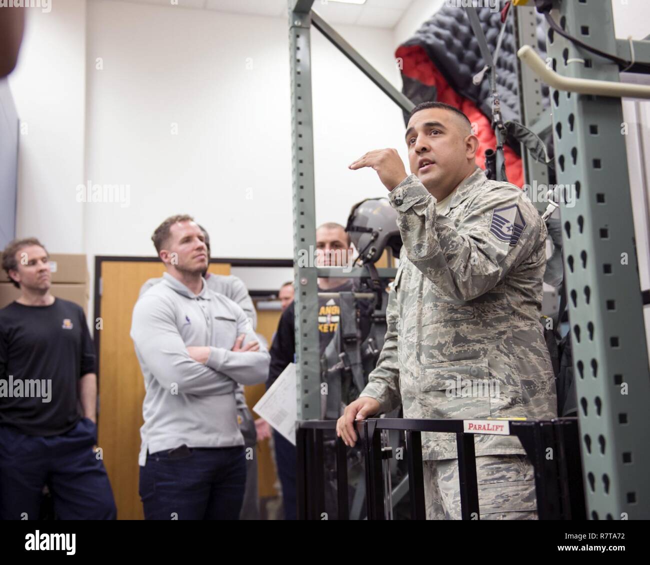 Master Sgt. Louis Soriano, eine flugzeugbesatzung Flug Ausrüstung Mitglied, Air National Guard, bespricht egress Verfahren zu einigen Mitgliedern der NBA Los Angeles Lakers bei einem Besuch am 4. April 2017, an der 149 Fighter Wing, an Joint Base San Antonio-Lackland, Texas gehabt. Die 149 FW ist ein F-16 Fighting Falcon formale Ausbildung Einheit innerhalb der US-Air Force Bildung und Ausbildung Befehl und ein Staat, militärische Gewalt unter dem Kommando und der Kontrolle der Texas militärische Abteilung. Stockfoto