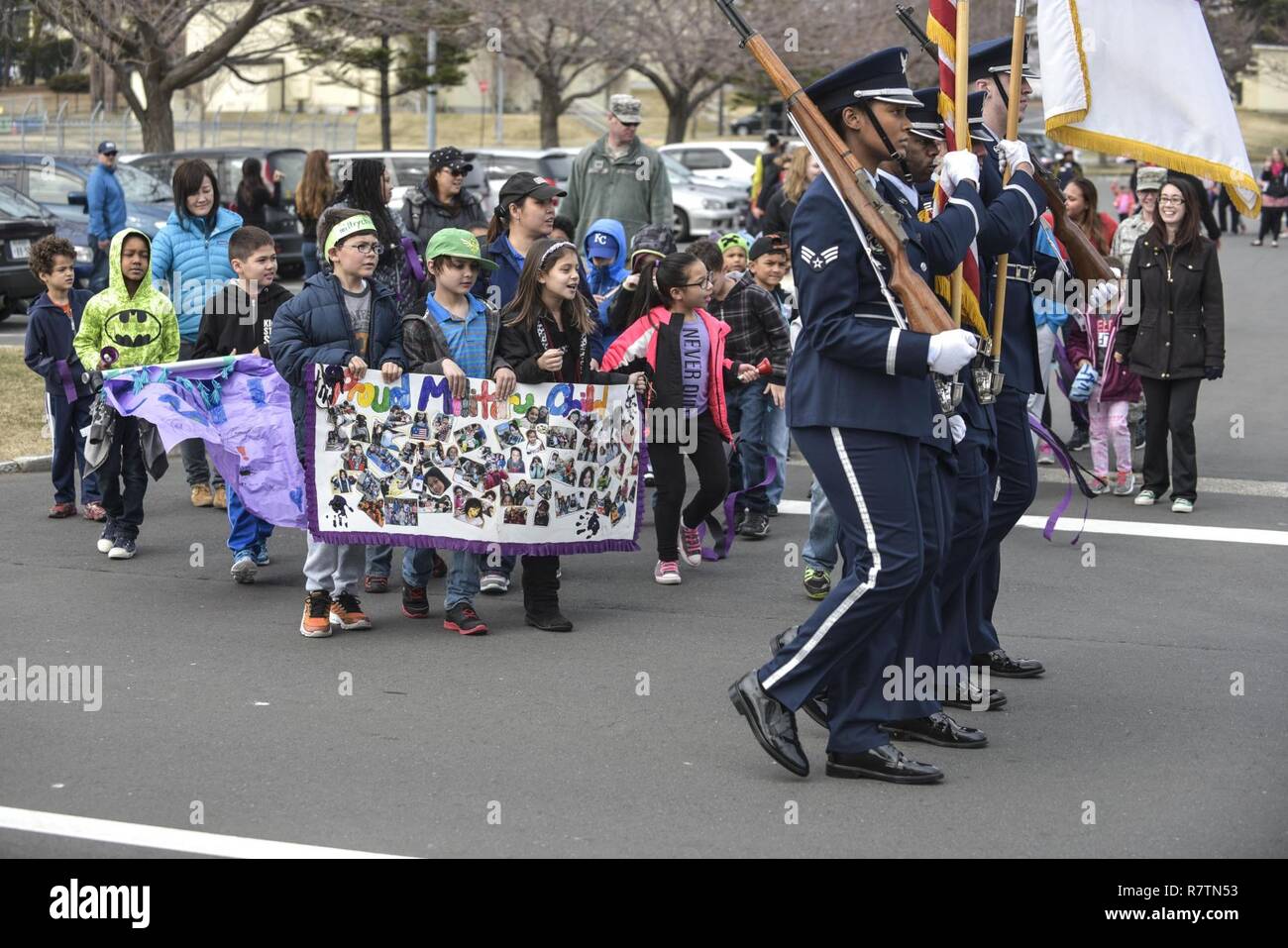 Misawa Ehre Wachposten führen Kinder, Eltern und Mitarbeiter aus dem Yoiko Child Development Center im Monat der militärischen Kind Parade bei Misawa Air Base, Japan, April 3, 2017. Die Parade empfohlene Mitglieder der Ehrengarde, die Feuerwehr Maskottchen Sparky und Poster von der CDC-Personal und Kinder vorgenommen. Stockfoto