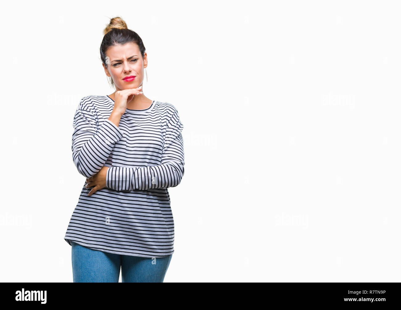 Junge schöne Frau casual Streifen Pullover über isolierte Hintergrund mit der Hand am Kinn über die Frage denken, nachdenklichen Ausdruck. Lächelnd mit Du Stockfoto