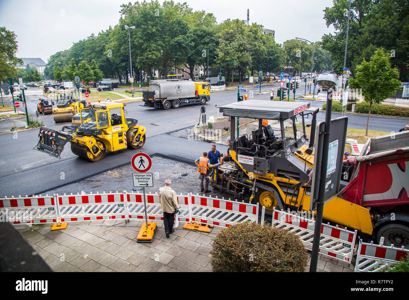 Maschinen und eine asphaltierte Spreader während Asphalt die Arbeit an einem großen städtischen Straße Baustelle, Essen Stockfoto