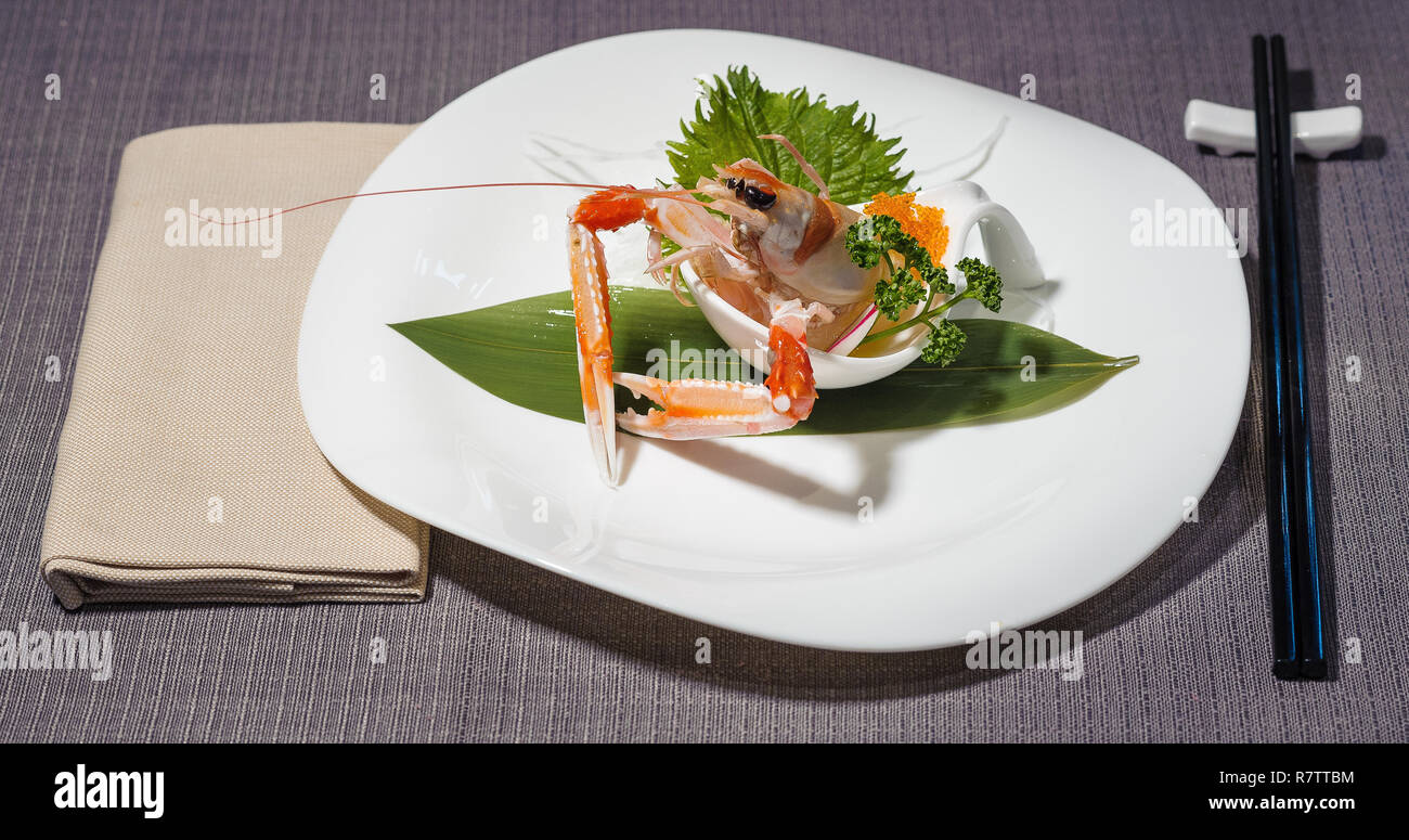 Raw Kaisergranat mit orange Kaviar, serviert mit Gemüse Julienne, grüne Blätter für die Dekoration Stockfoto