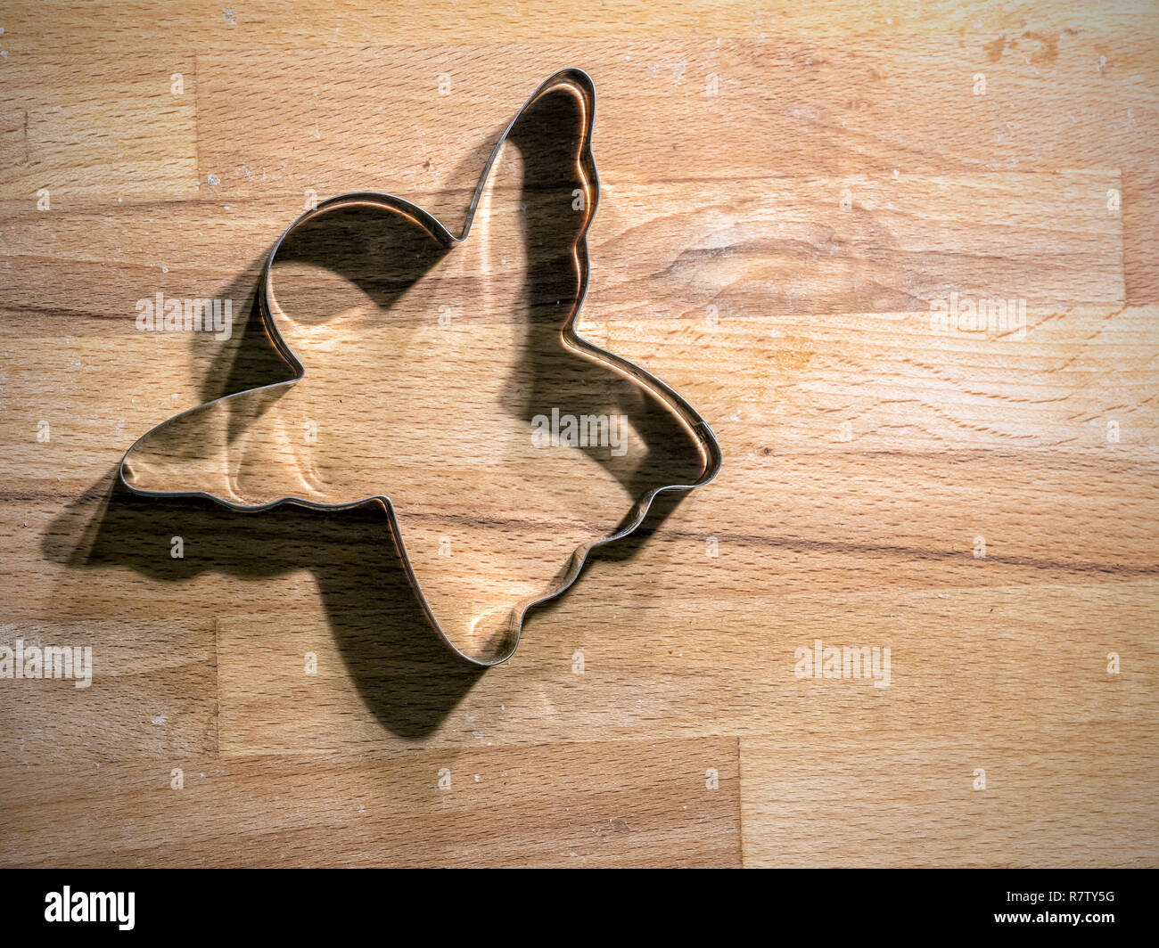 Engel-förmige Metall Cookie Cutter ein Holzbrett Stockfoto