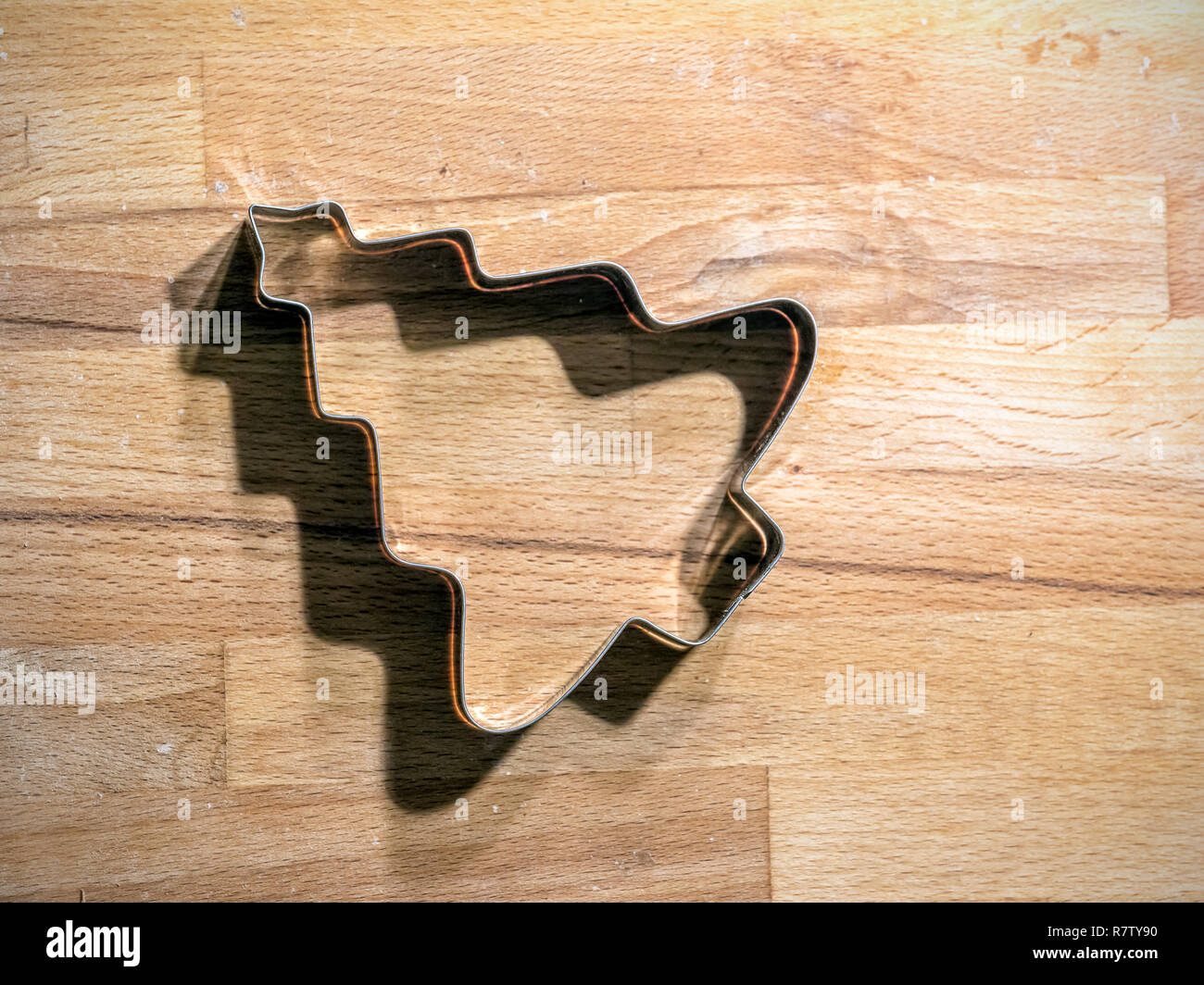 Christmas Tree-förmige Metall Cookie Cutter ein Holzbrett Stockfoto