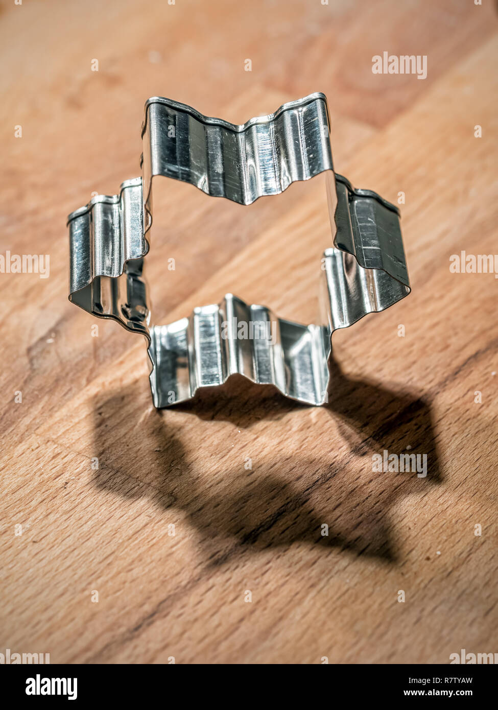 Sternförmige metall Cookie Cutter ein Holzbrett Stockfoto