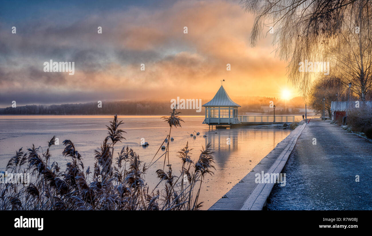 Winterlicher Sonnenuntergang über einem kleinen See in Schweden Stockfoto